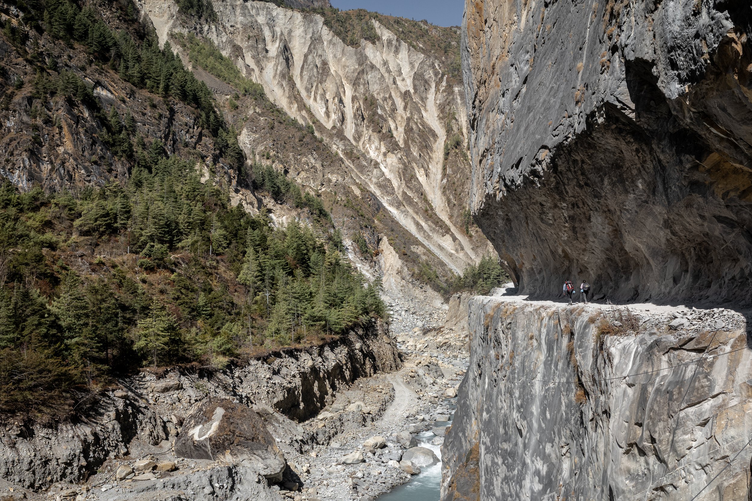 A section of the Upper Annapurna circuit cut into a narrow cliff in a deep canyon