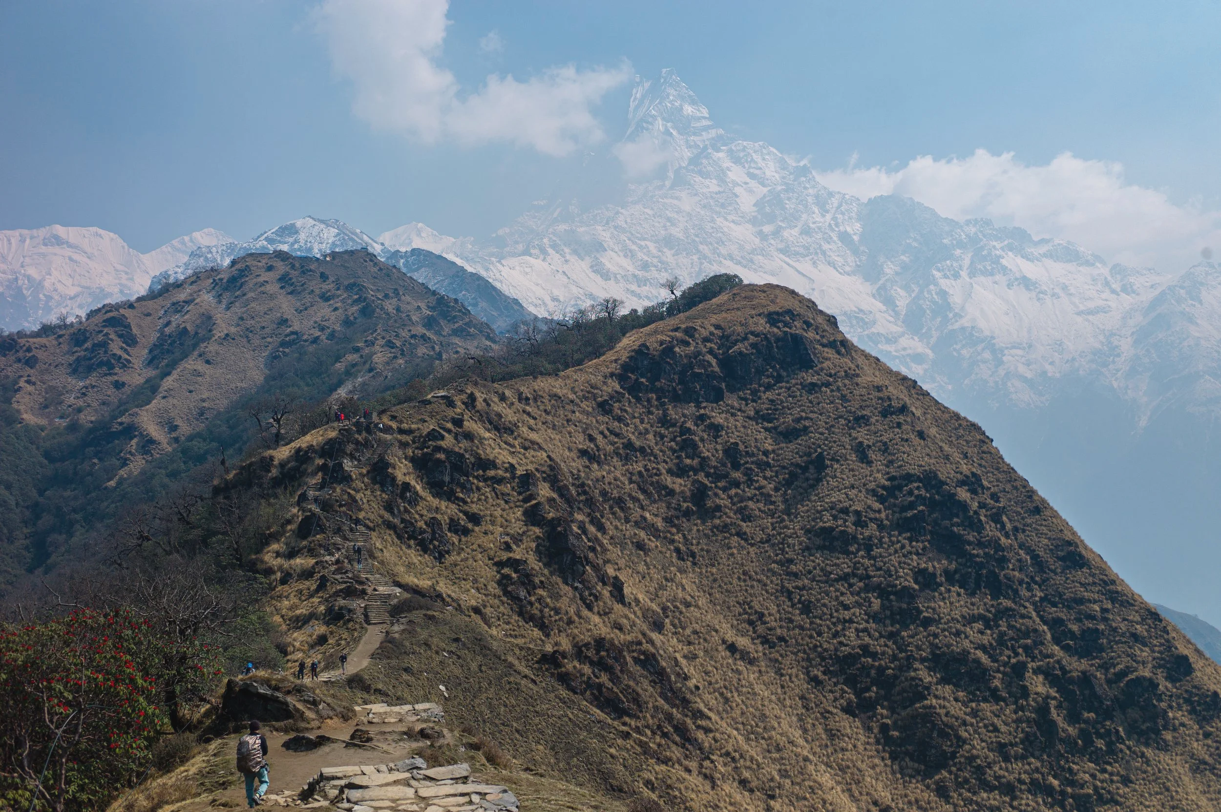 Hikers climb a high mountain ridge to gain closer views of Machhapuchhare