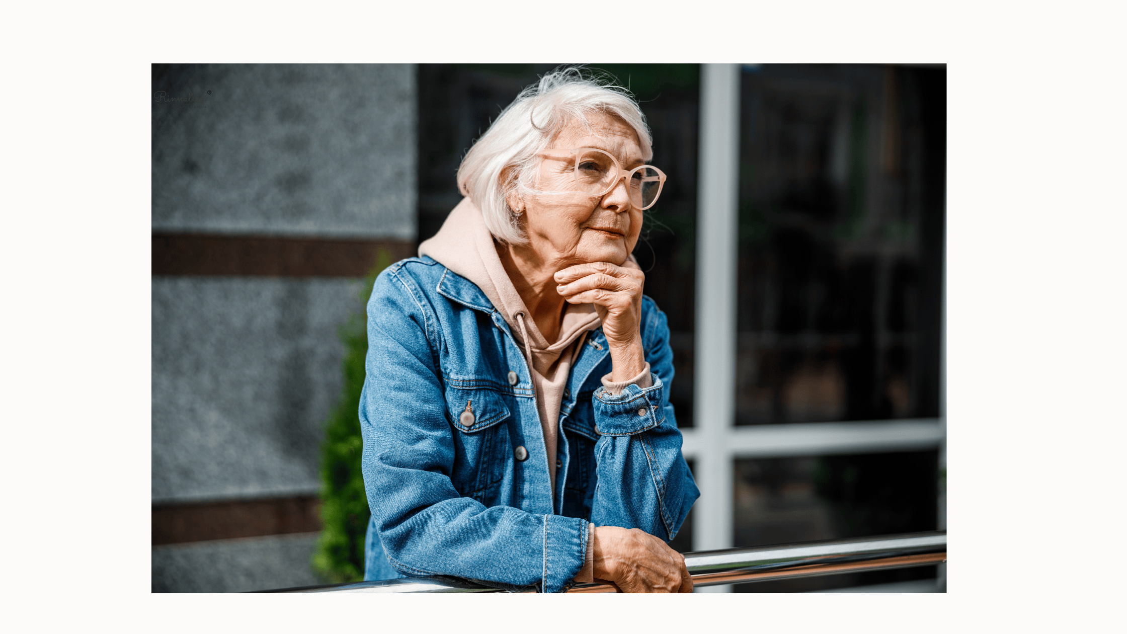 Vanhempi hyväkuntoinen nainen nojaa parvekekaiteeseen pohtien