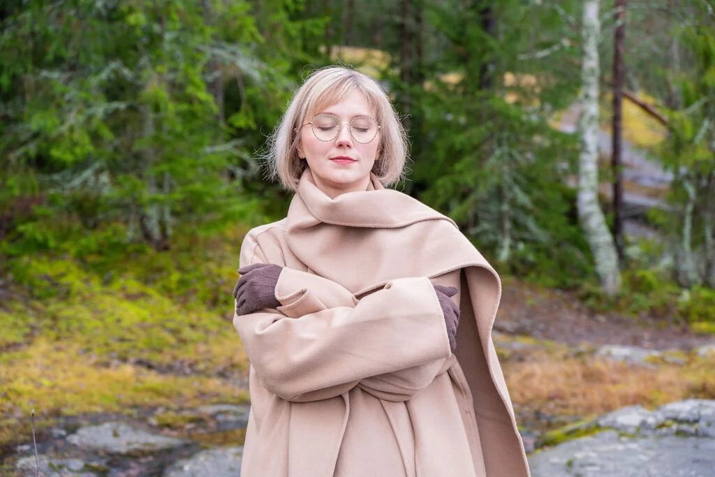 Rinnallesi Oy:n perustaja on sulkenut silmänsä ja halaa itseään lempeästi metsässä