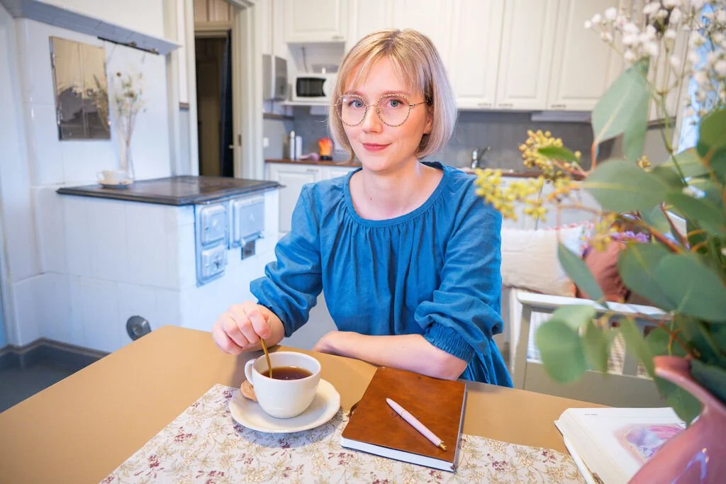 Yrityksen perustaja istuu pöydän ääressä teekupin kanssa ja valmistautuu vastaanottoon