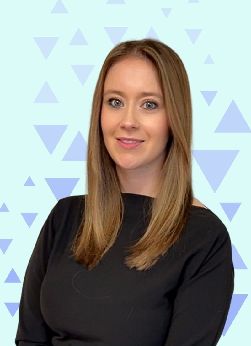 A young woman with long, straight, light brown hair, wearing a black top, smiling in front of a light blue background with blue triangular patterns.