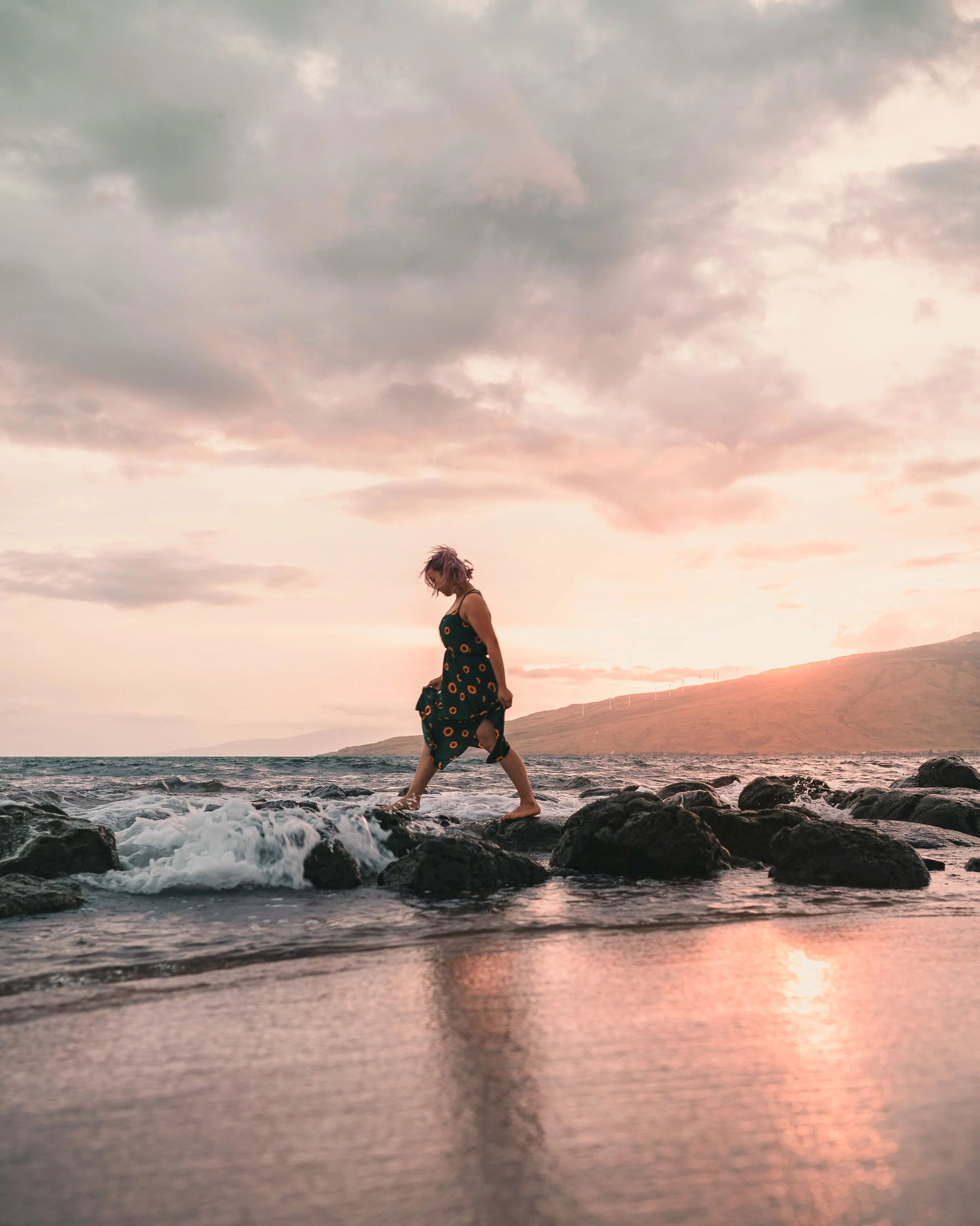 woman walking along the shoreline in Kihei, Maui at sunset