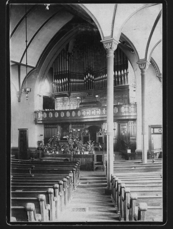 Sanctuary of First Baptist Church beautiful woodwork, pews, arches, black and white