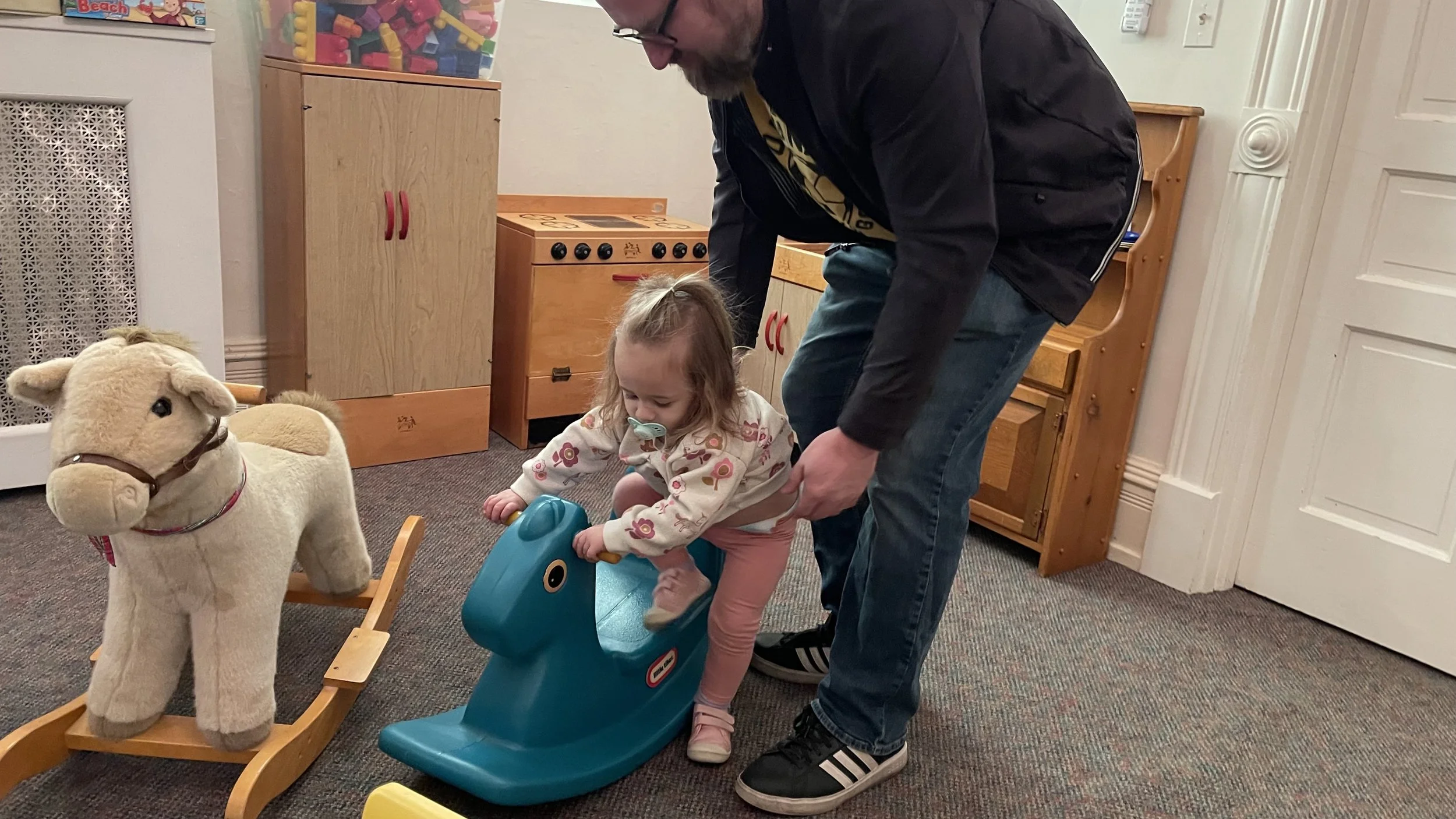 child on rocking horse in nursery at church