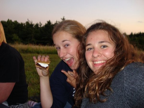 two teens laughing at campfire