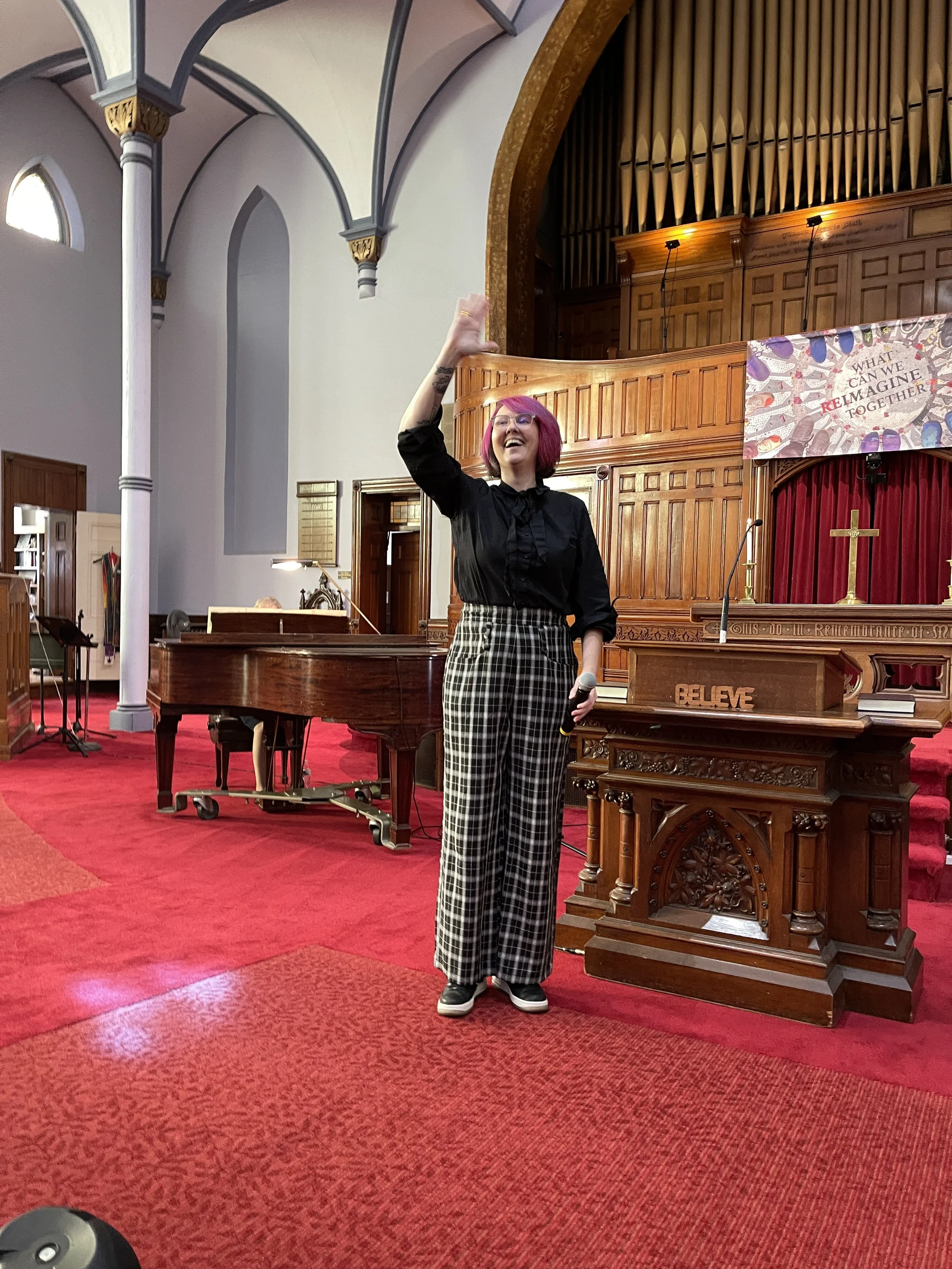 Image of pastor alissia waving in front of the pulpit