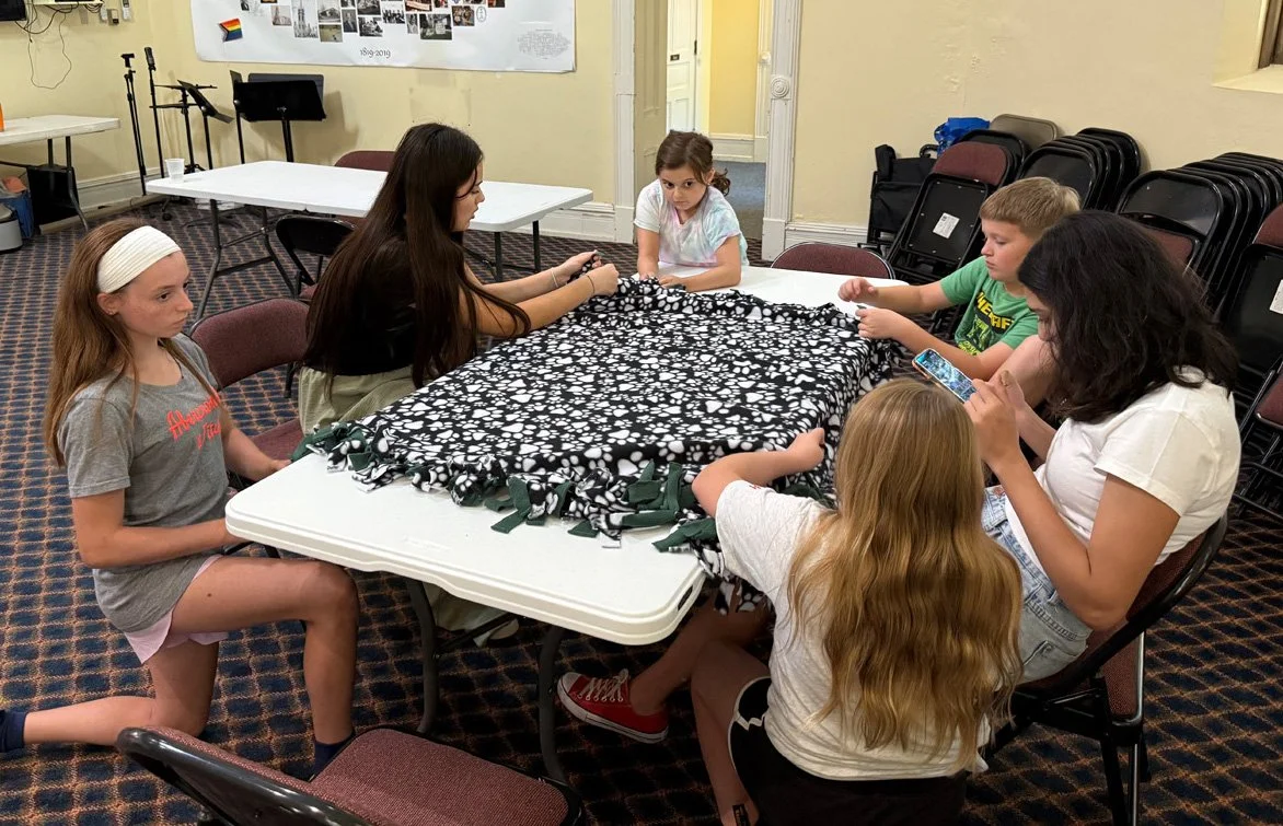 Children making blankets to give to children who need them