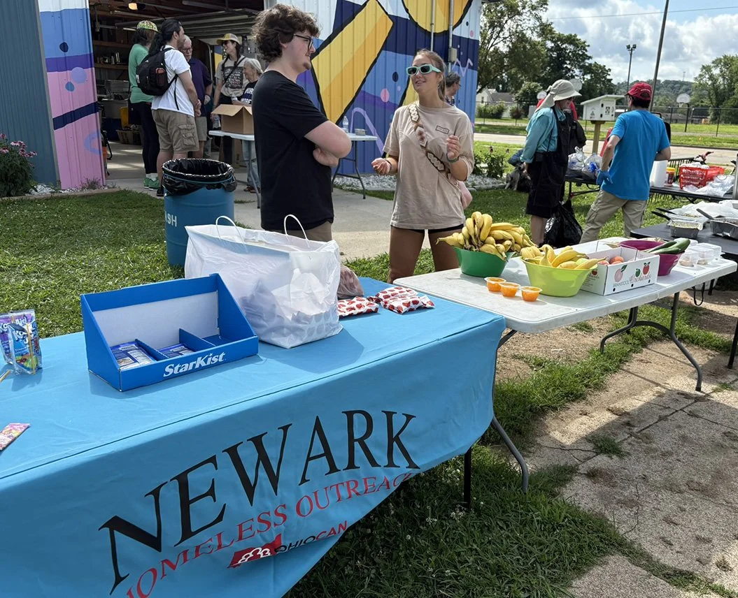 Teen Servers at the Newark Homeless Outreach table with others behind them
