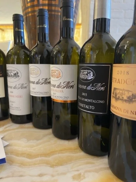 Wine bottles from Casanova di Neri, including Brunello di Montalcino, displayed during an Italian wine tasting.