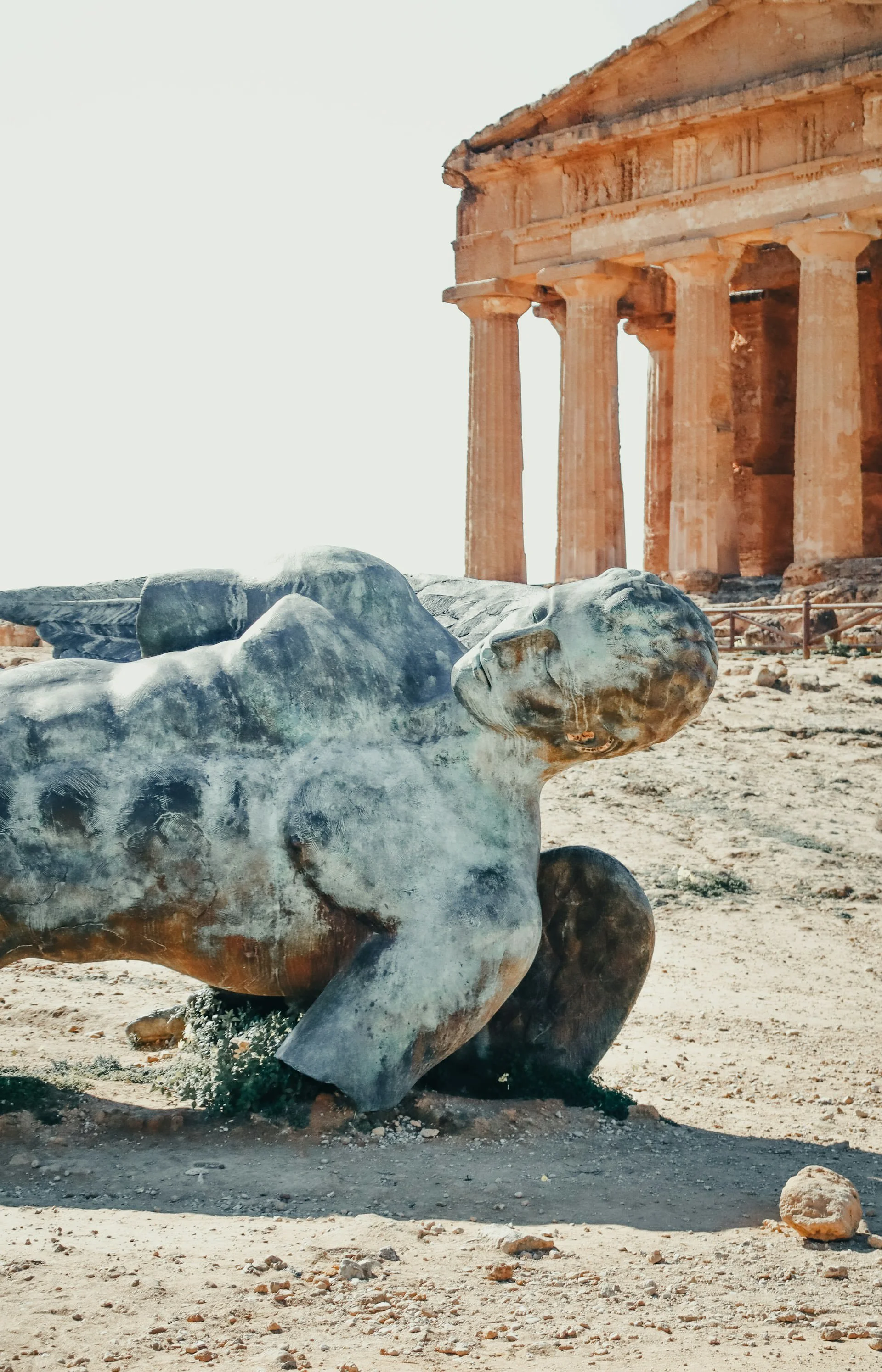 Reclining fallen statue sculpture near the ancient Greek Temple of Concordia at the Valley of the Temples in Agrigento, Sicily.