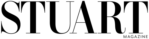 Close-up of a silhouette of a person with an outstretched arm holding a microphone against a dark background.