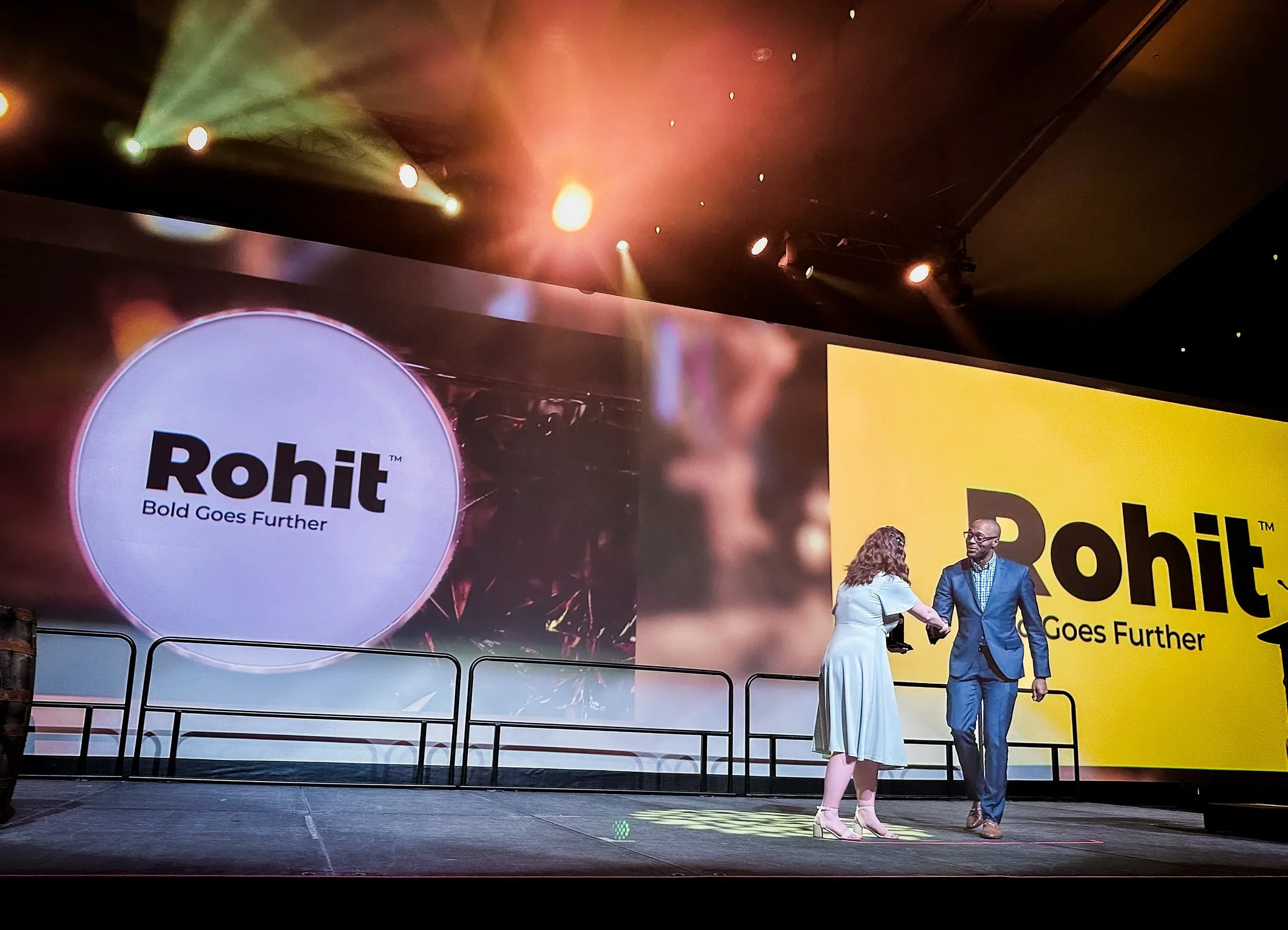 Nathan K. Walters shaking hands on stage at the BILD Awards of Excellence, accepting the award for the national rebrand of Rohit Group in the marketing category.