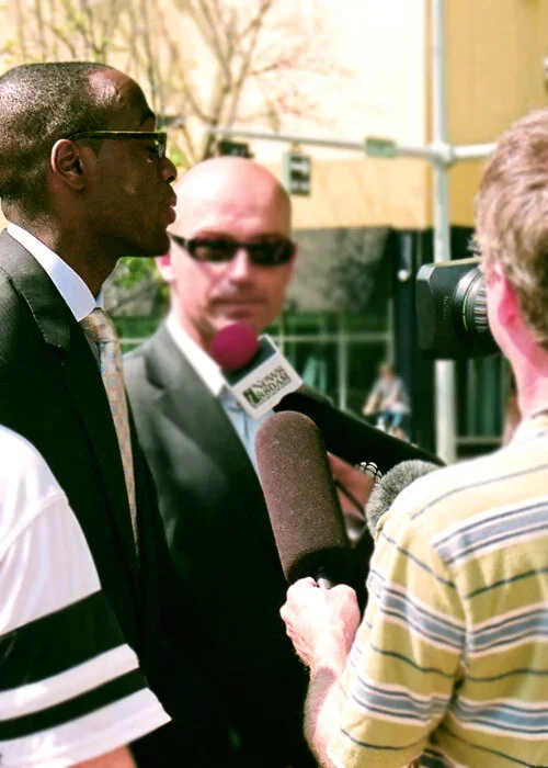 Nathan K. Walters being interviewed by reporters at a media scrum at City Hall for the LoyaltyOne / AIR MILES partnership.