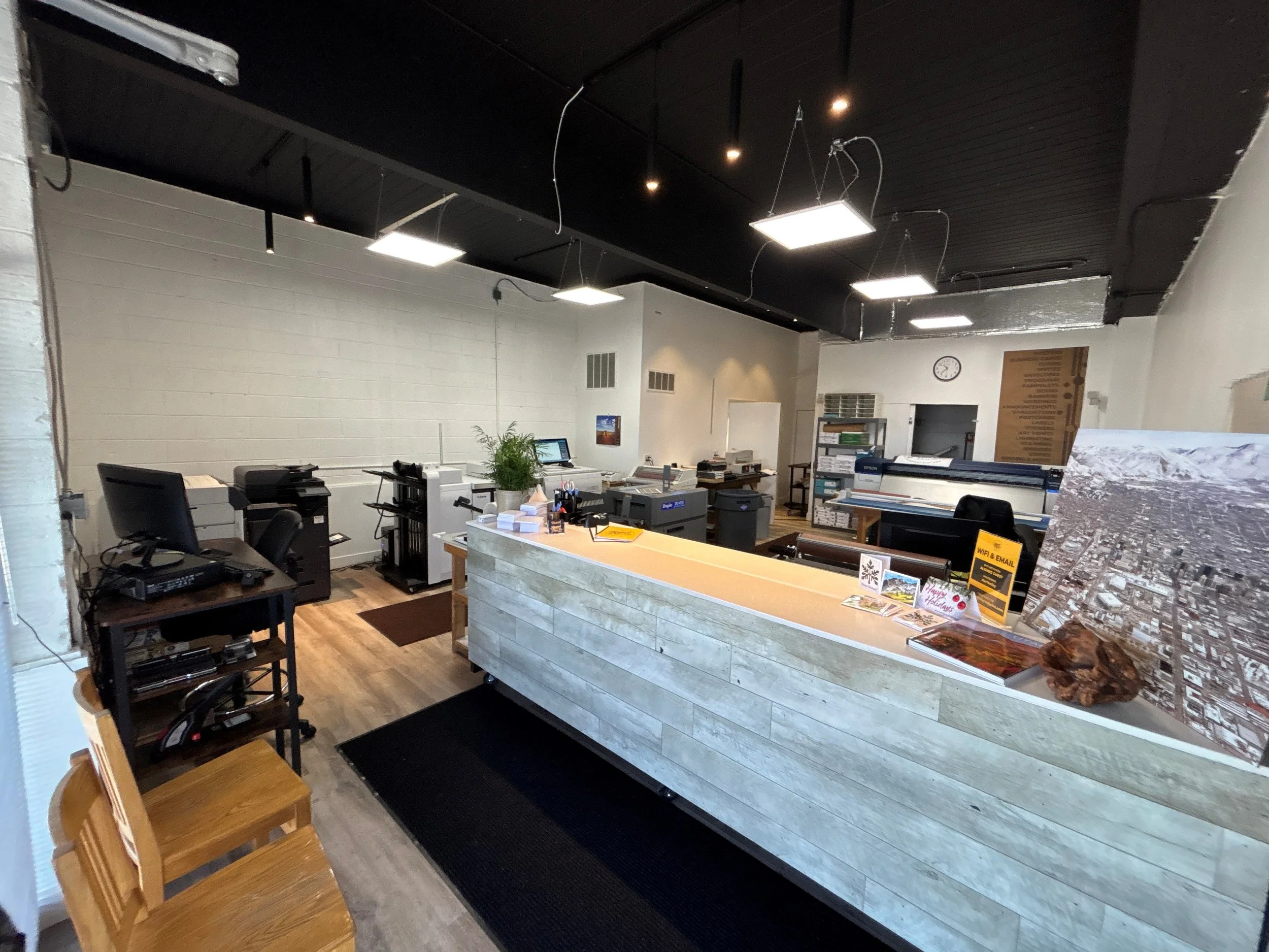 interior of a copy and print shop in salt lake city. shows the front counter and some machinery and suspended lighting