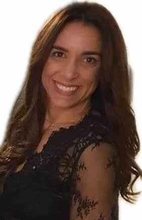 Portrait d'une femme souriante avec des cheveux longs et bruns, portant une robe noire en dentelle.