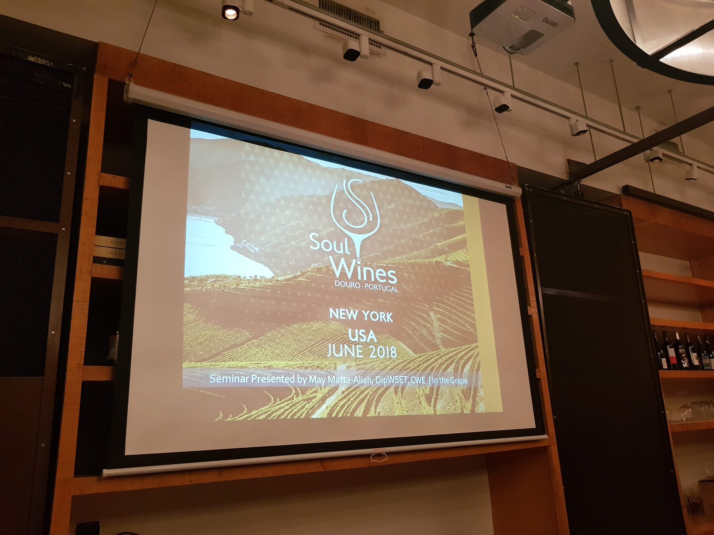 Presentation slide screen showing a wine seminar titled "Soul Wines" with location Douro, Portugal, held in New York, USA, June 2018. The slide includes a background image of a vineyard and mountain landscape, with details about the seminar and prese
