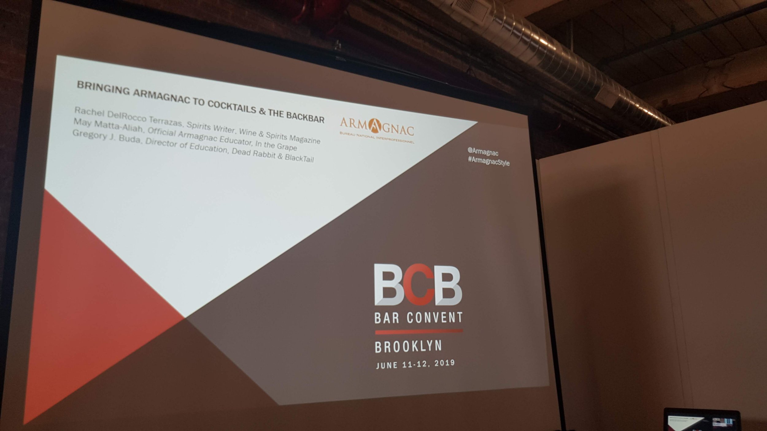 Presentation slide titled 'Bringing Armagnac to Cocktails & the Backbar' with details about Rachel DelRocco Terrazas, May Matta-Aliah, and Gregory J. Buda, and indicating the event 'BCB Bar Convent Brooklyn June 11-12, 2019' with social media handles