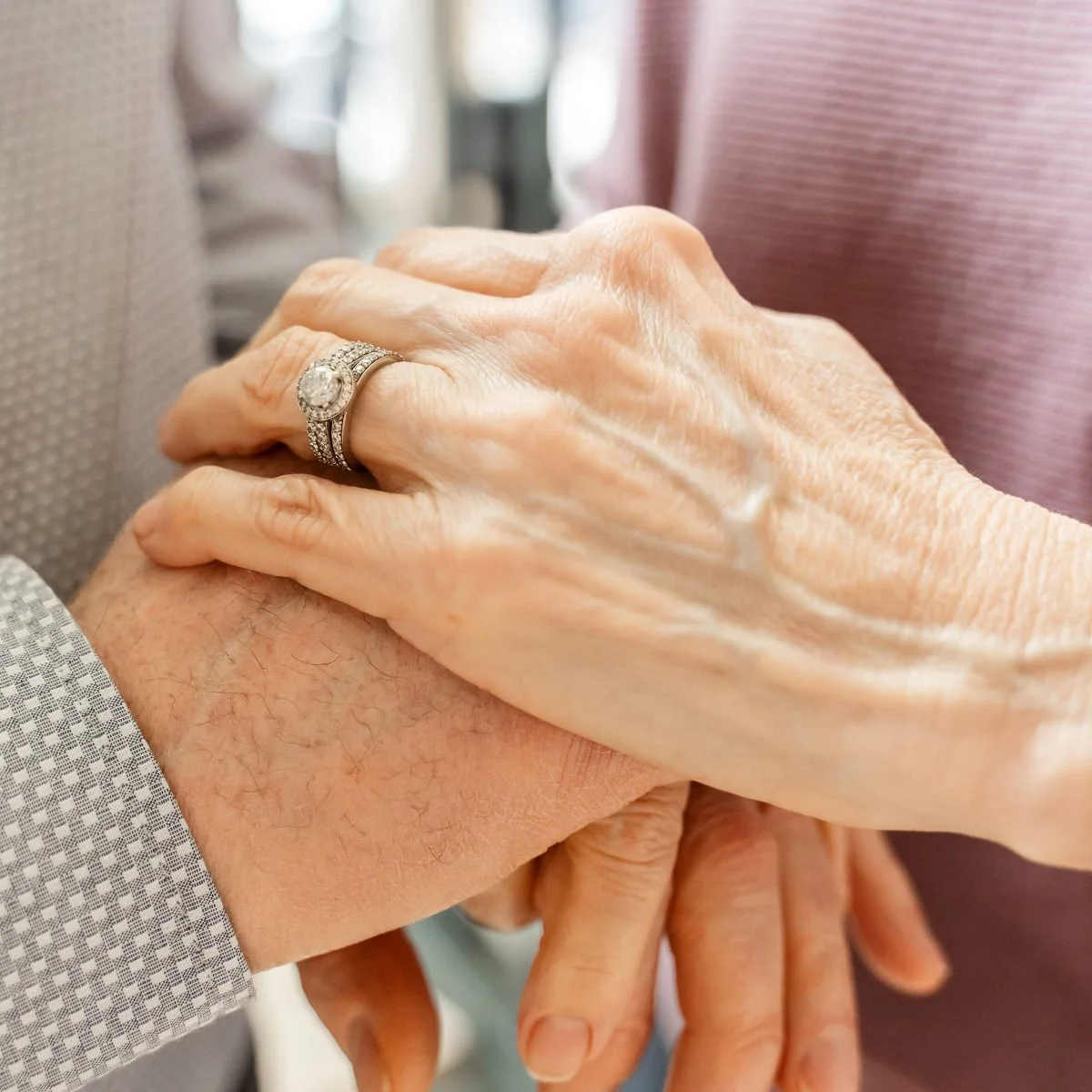 Close-up of two older hands holding in a moment of comfort and support