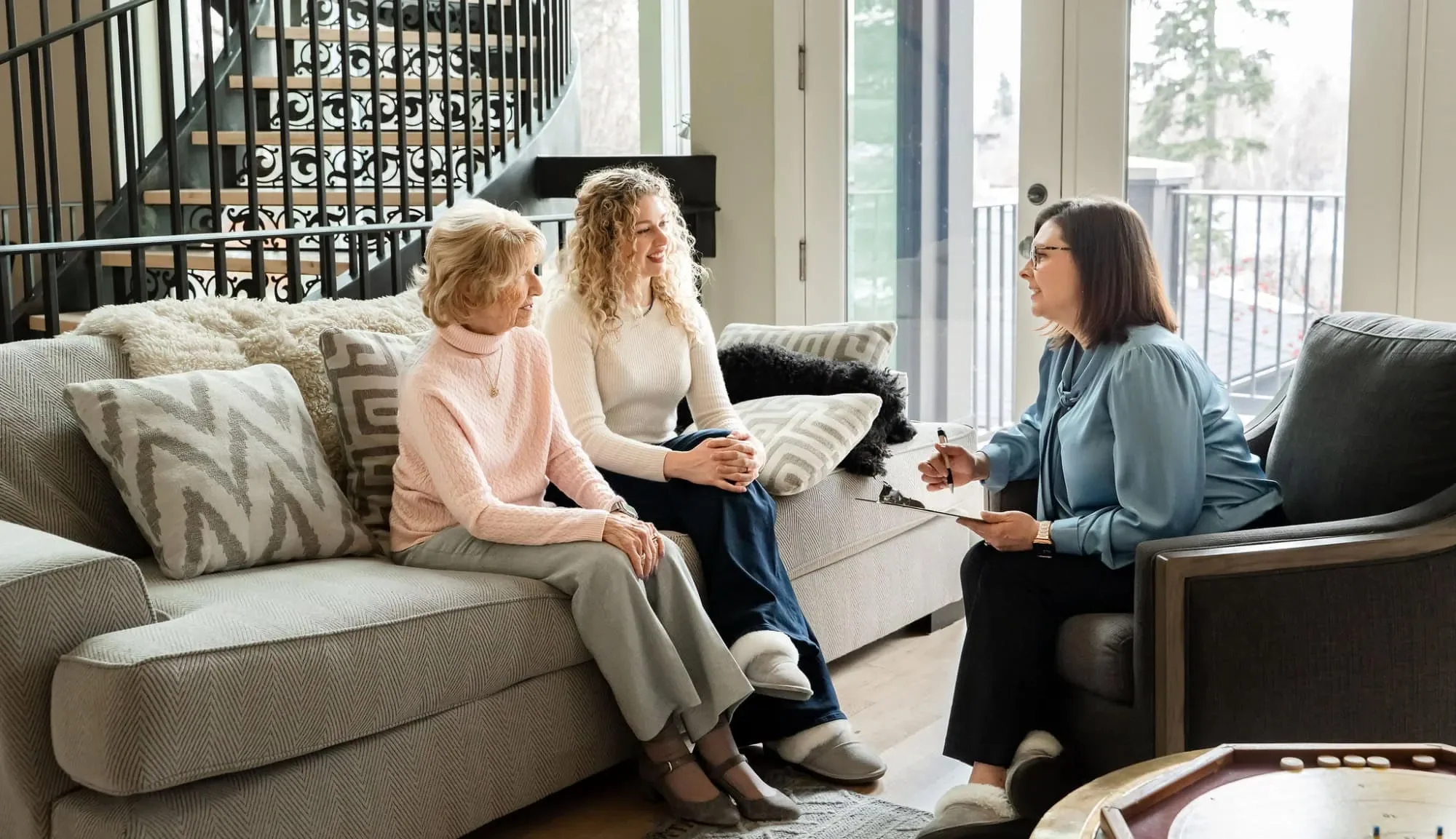 Caregiver speaking with a client  and family during an in-home care visit