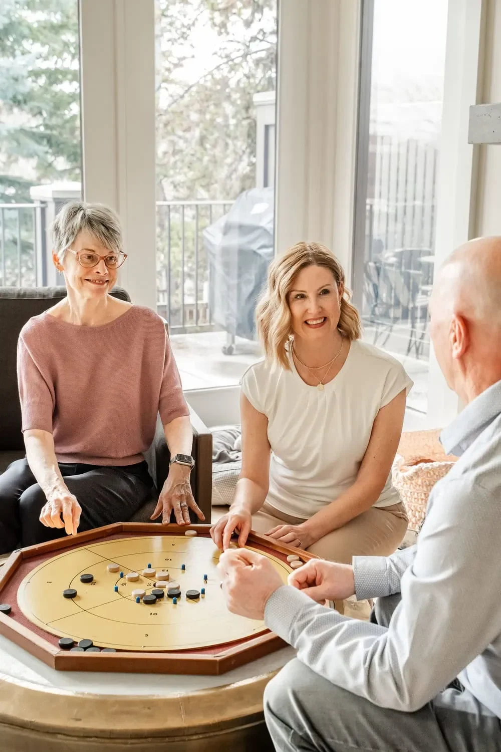 Companion care visit with a nurse playing a game with two older adults at home in Calgary