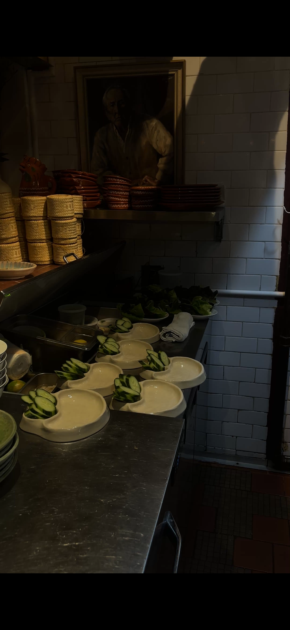 Shelves with stacked plates and bowls, including some shaped like animal heads, in a restaurant kitchen.