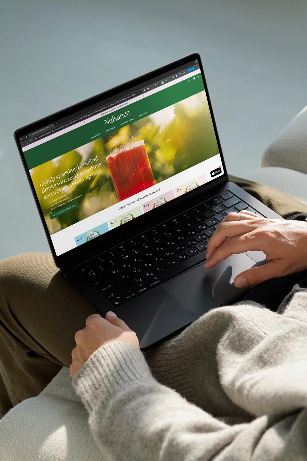 open laptop on lap showing nuisance drinks shopify website
