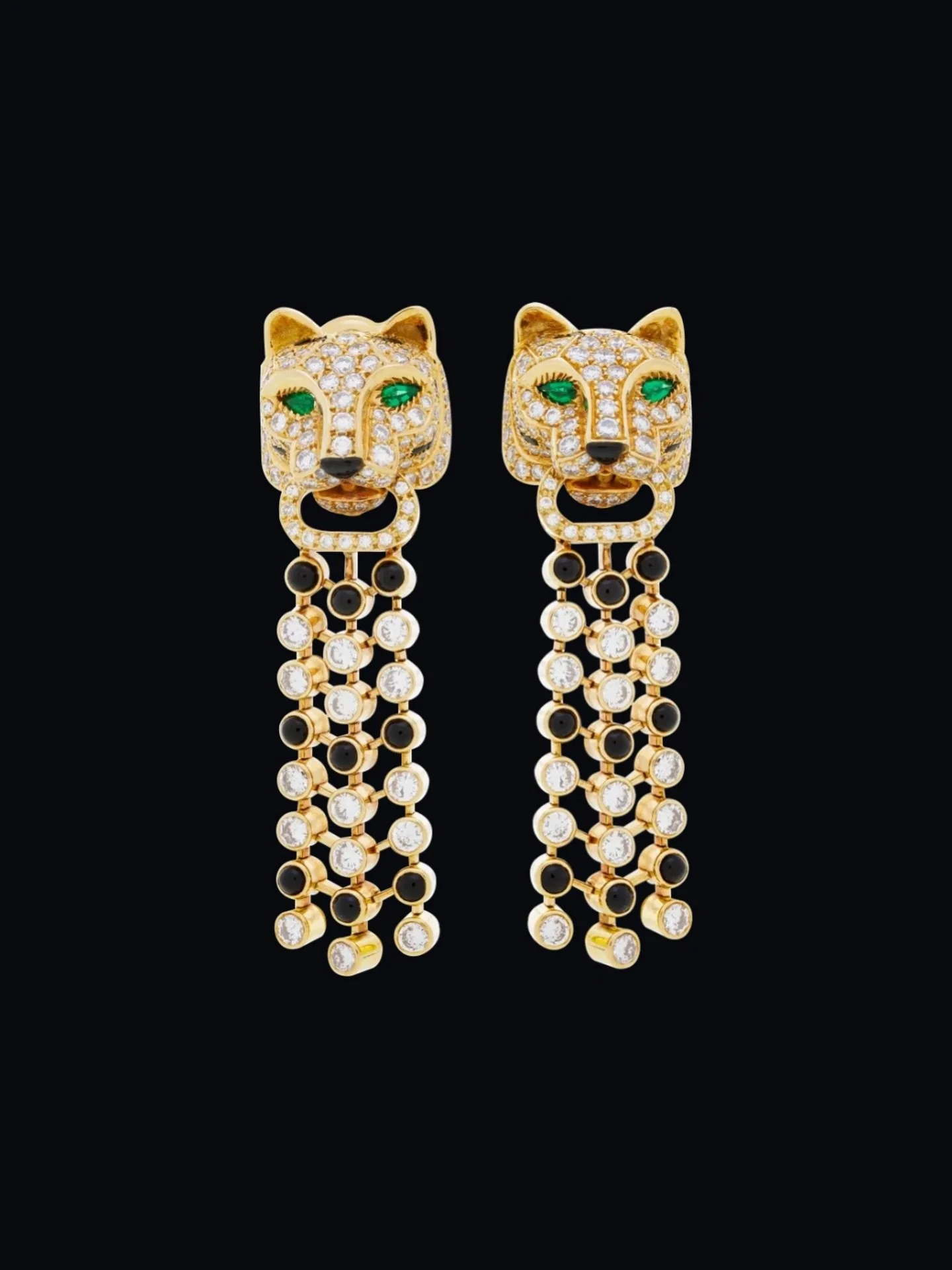 Cartier 18k (750) gold pair of panther earrings, brilliant-cut diamond pav&eacute; heads &amp; cabochon onyx styling the coat, onyx truffle &amp; pear-shape emerald eyes &amp; retaining in their mouth an articulated cascade set with onyx &amp; brilli