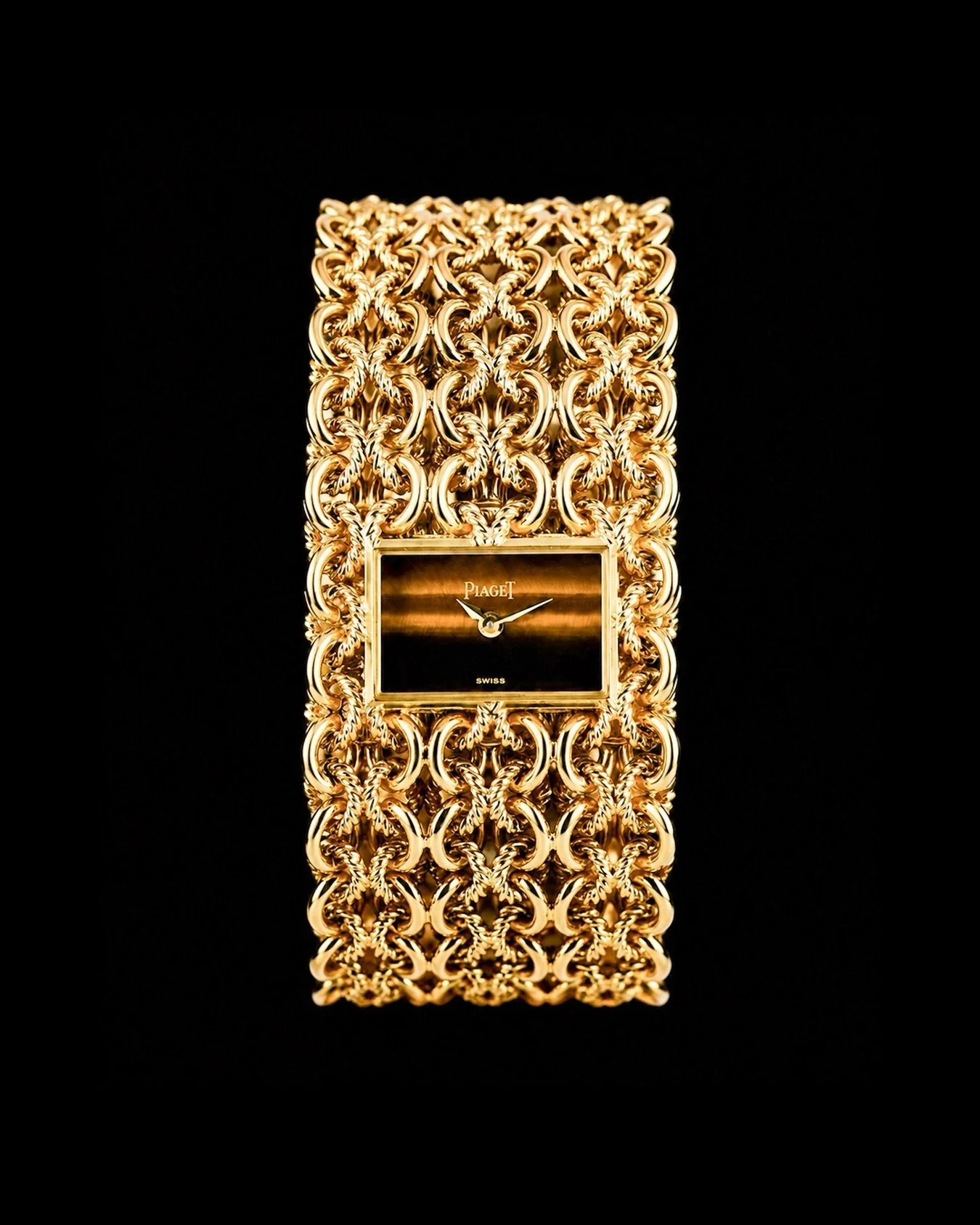 Piaget Ladies Yellow Gold Tiger&rsquo;s Eye Dial Bracelet Manual Wristwatch. Sophisticated and glamourous, this mid-century treasure nestles a rectangular tiger&rsquo;s eye watch in a woven bracelet of high-polished and matte-finished golden threads.