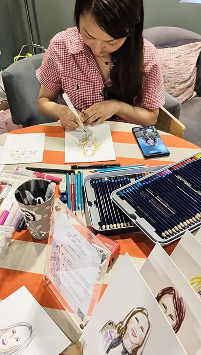 Siya Liu drawing a live portrait at an event illustration station.