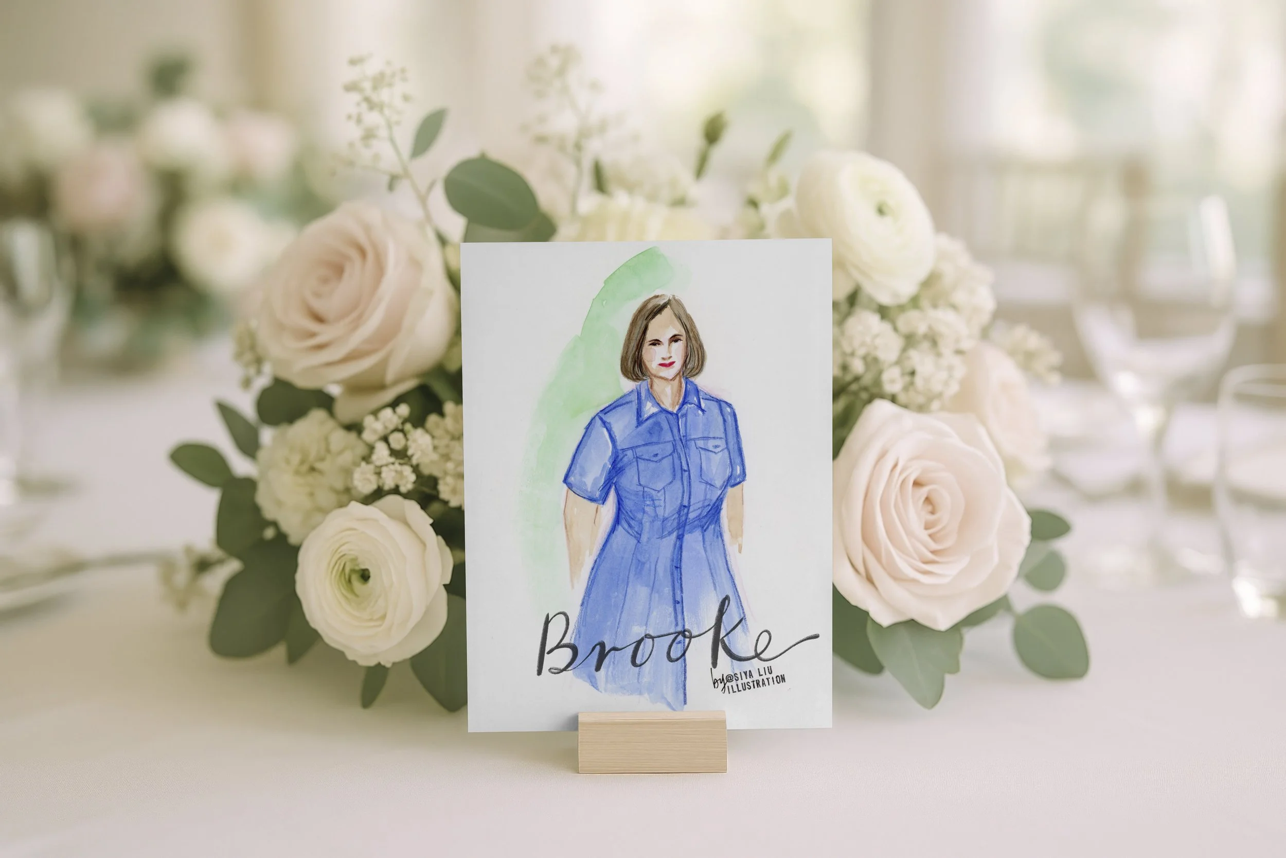 A fashion illustration of a lady in a navy blue dress, named Brooke, works as a luxury event or wedding place card and keepsake, hand-illustrated by Siya Liu, Live Event Artist at a live event.