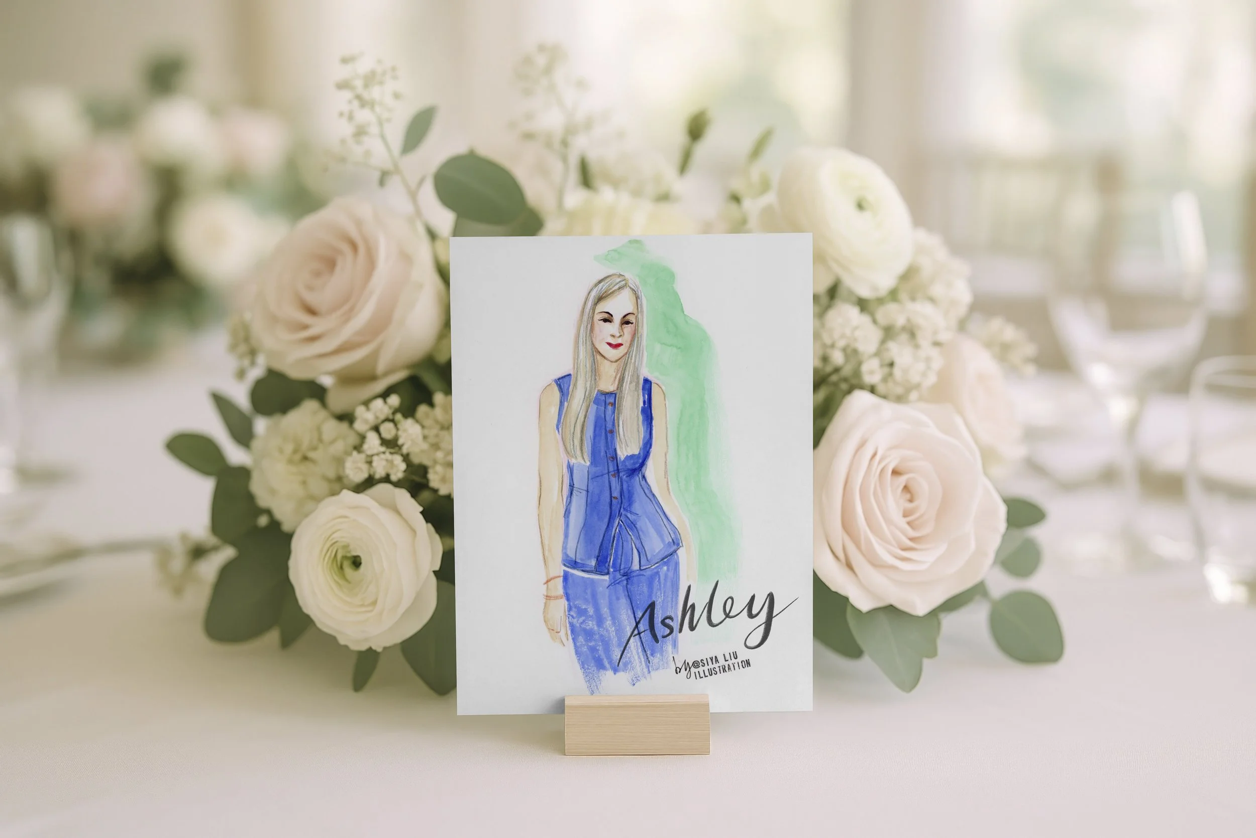 A fashion illustration of a lady in a navy blue dress, named Ashley, as a luxury event or wedding place card and keepsake gift, hand-illustrated by Siya Liu, Live Event Artist at a live event.