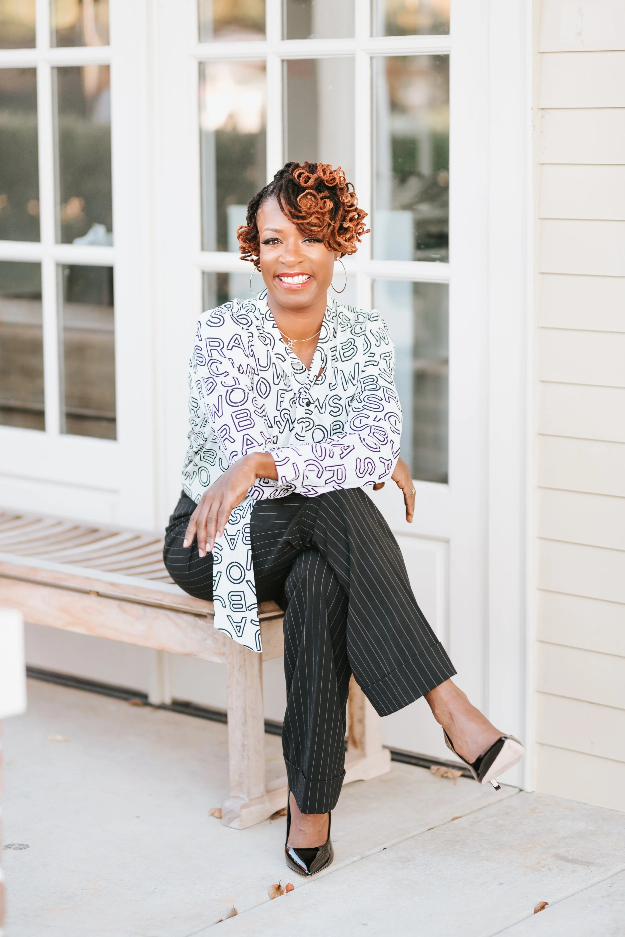 Sonia Toson sitting by doors smiling
