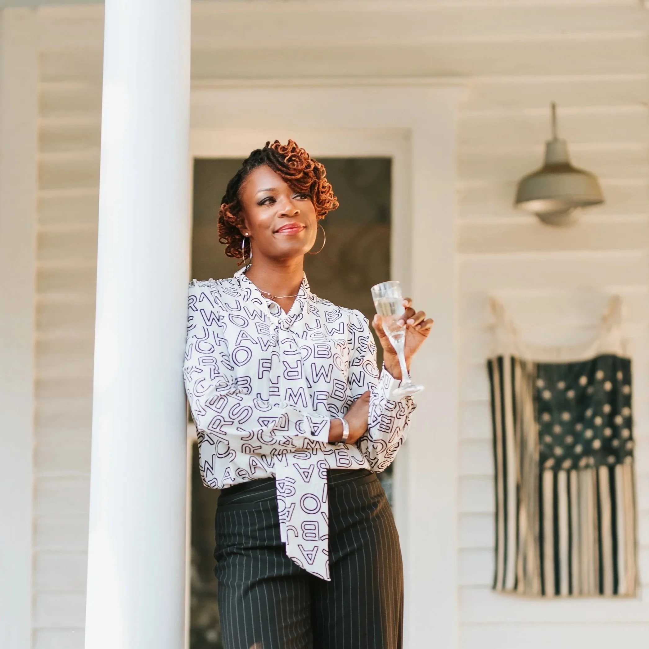 Sonia leaning against poll with champagne
