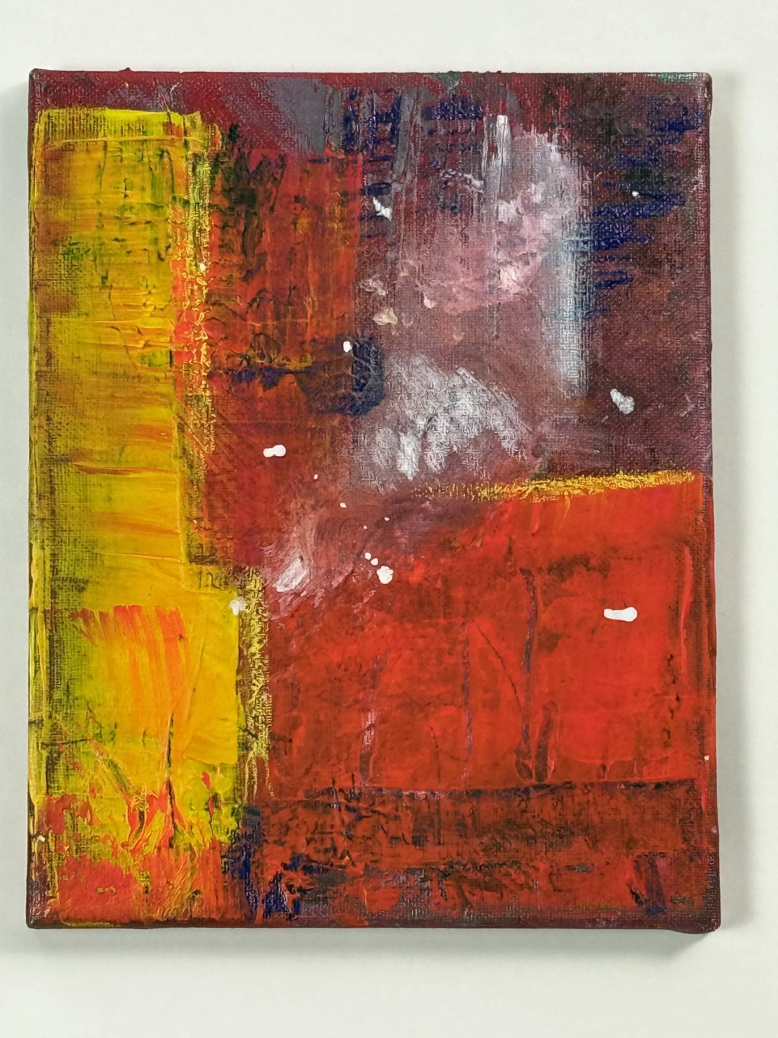 Close-up of an abstract acrylic painting with textured red, yellow, orange, purple, and white colors on canvas.