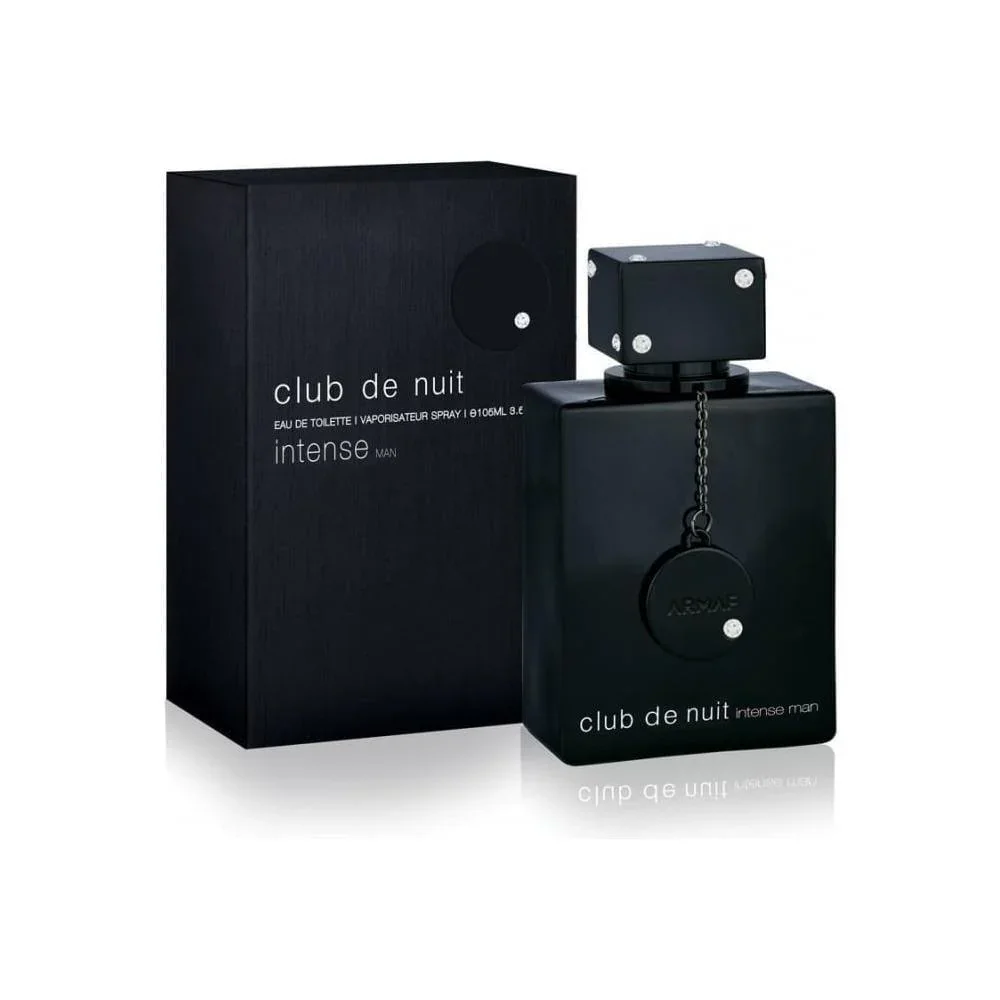 A black bottle of perfume labeled 'club de nuit intense man' standing next to its matching black box with similar text, reflecting on a white surface.