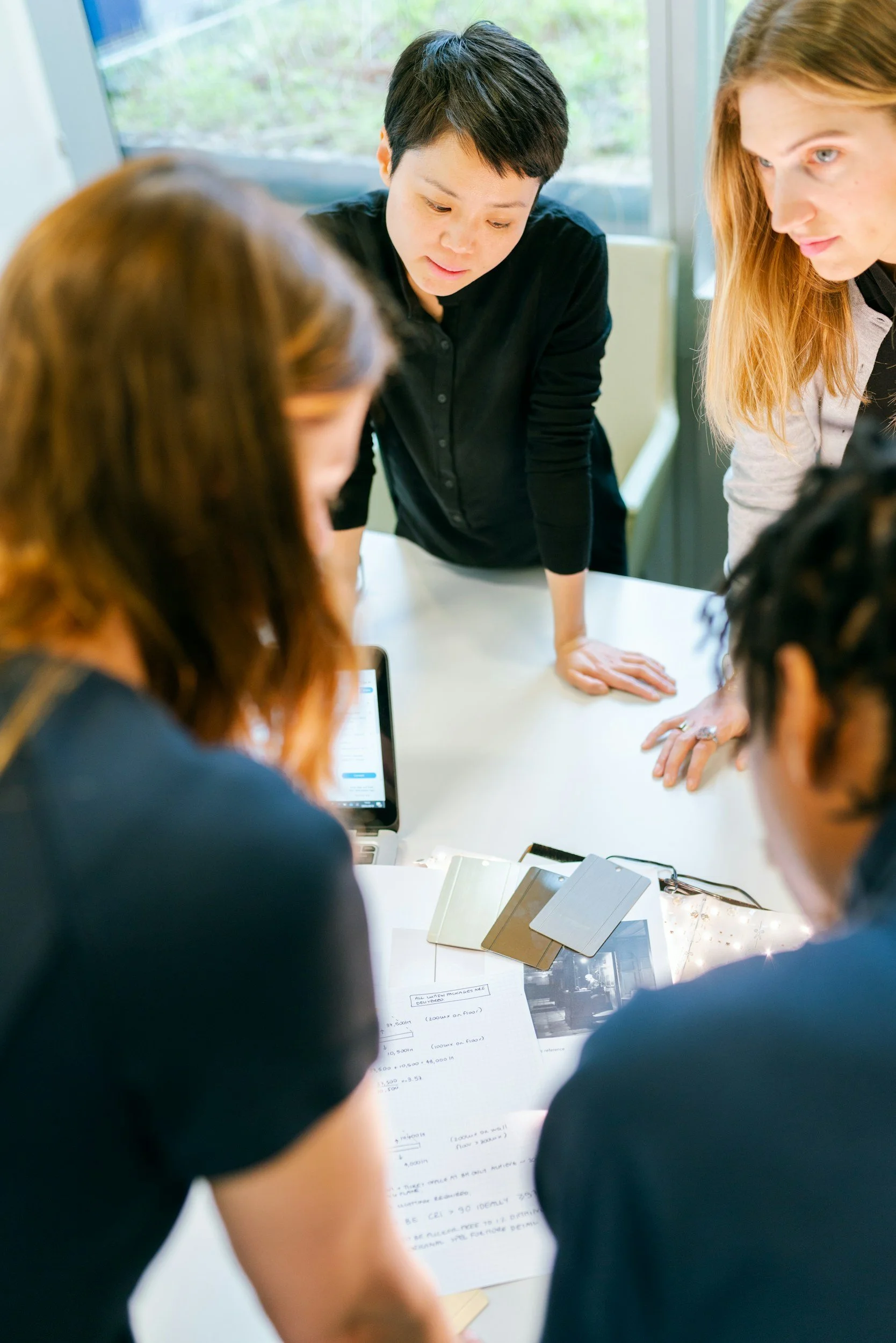 Image of a group of owmen at a boardroom table, working on laptops and ipads