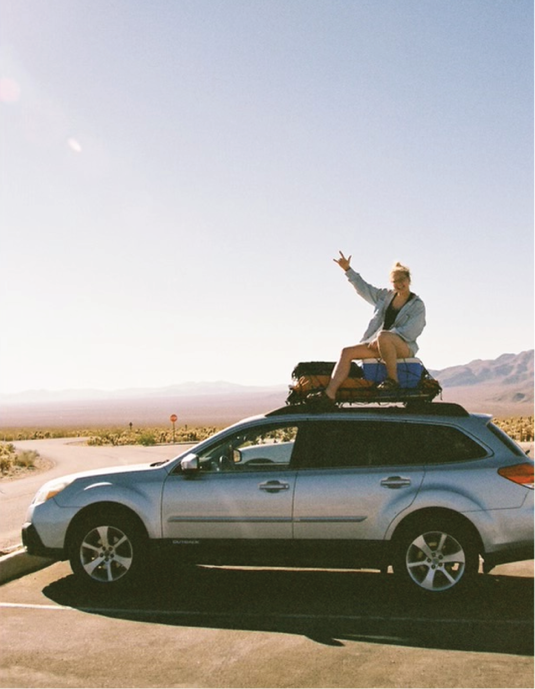 Basecamp Collective founder sitting on a Subaru adventure build in the desert, representing outdoor freedom and minimalist car camping design.