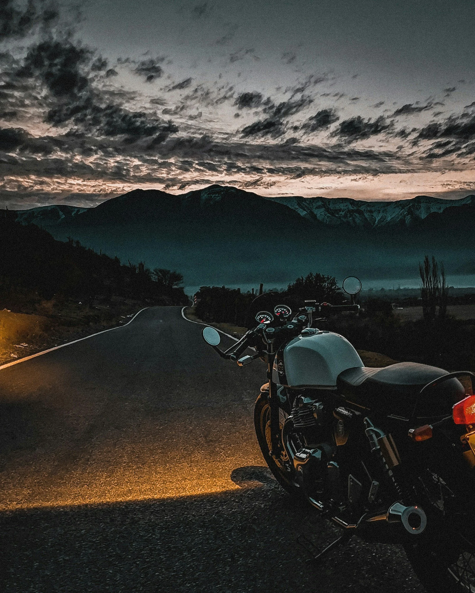 motorcycle parked at sunset with mountain background