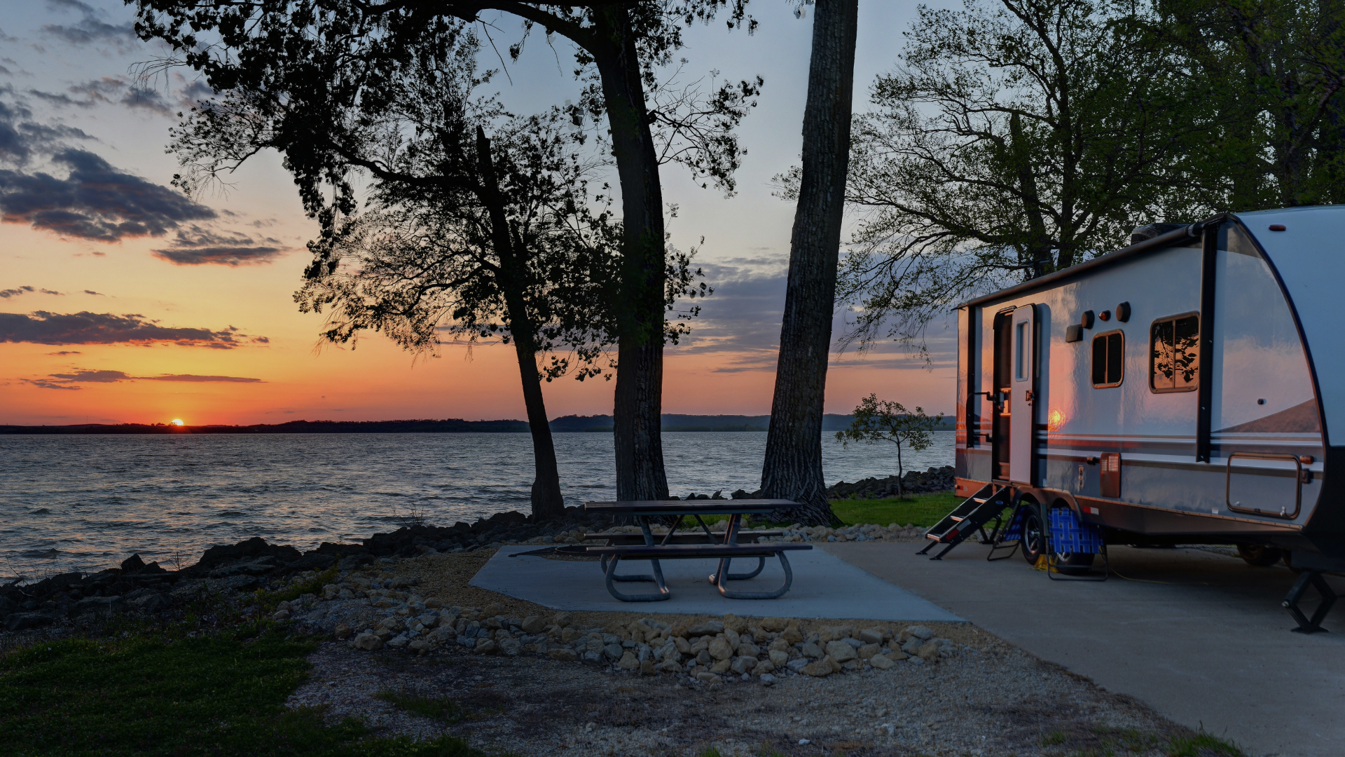 trailer parked at sunset next to lake