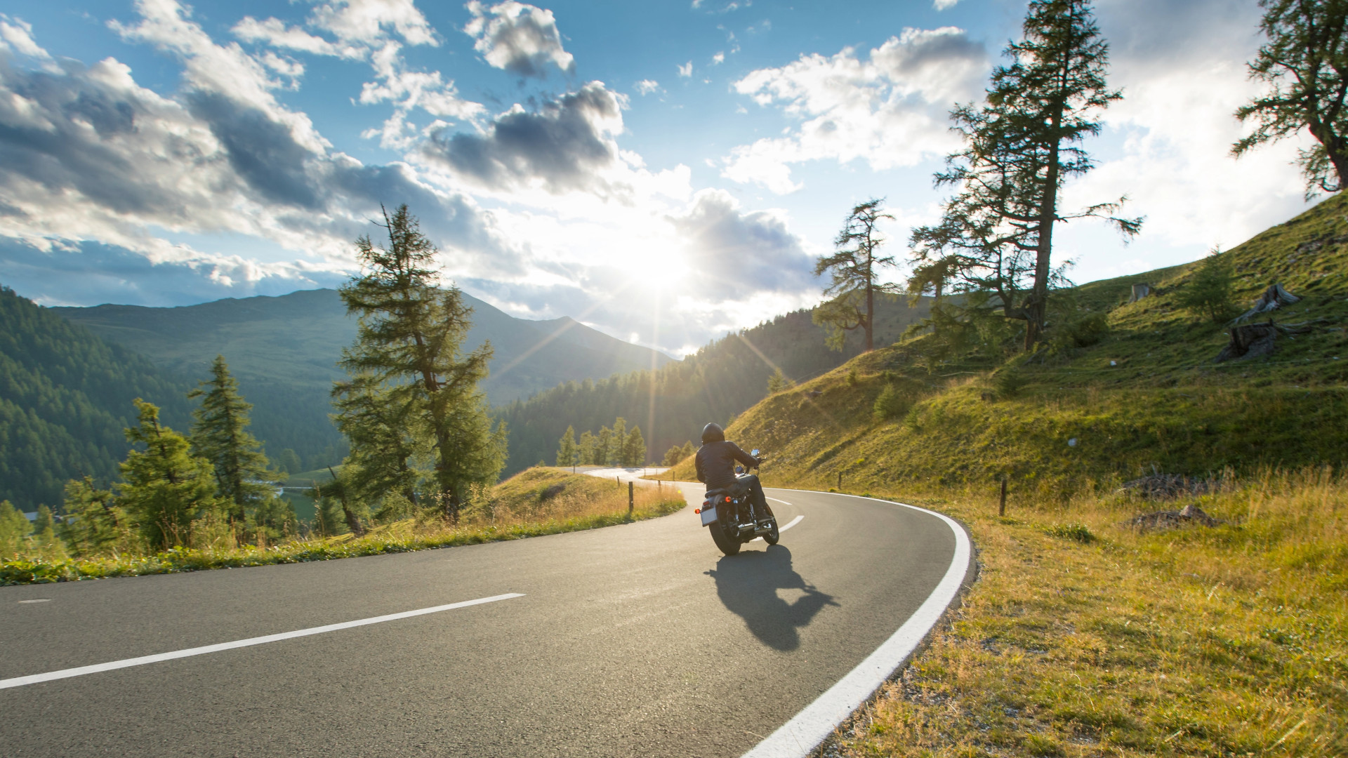 motorcycle riding a winding road with mountain background