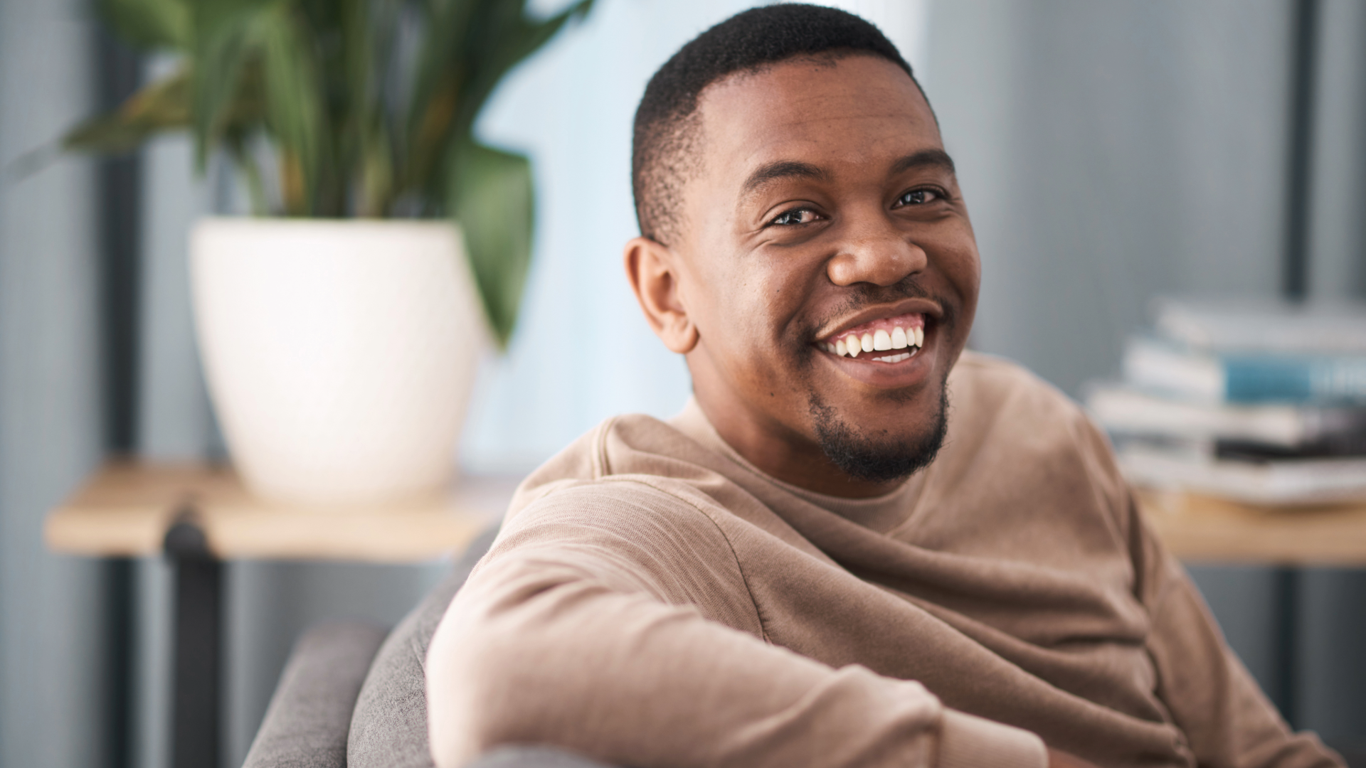 man sitting on sofa smiling