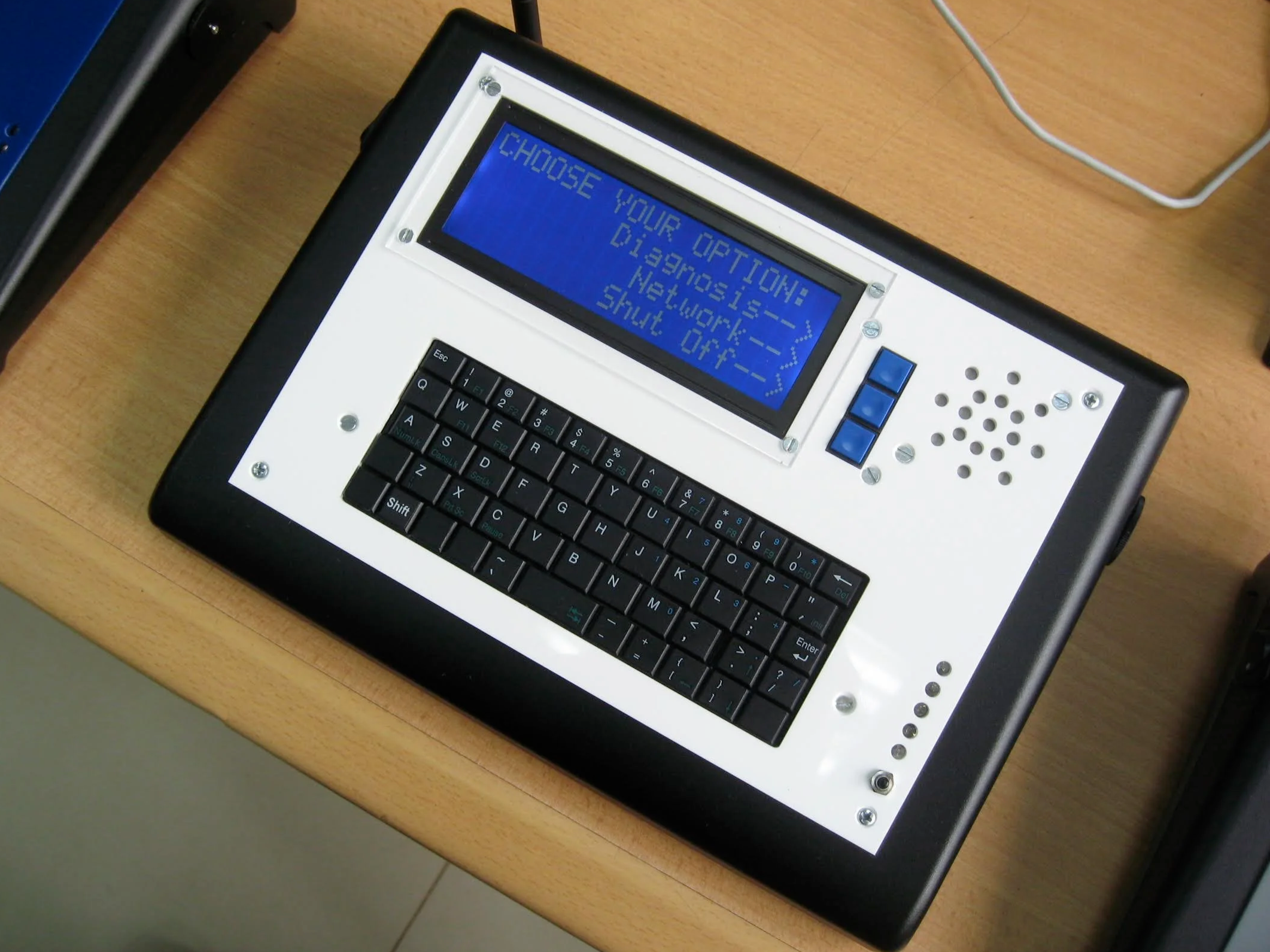 A white handheld electronic device with a keyboard a blue screen and buttons