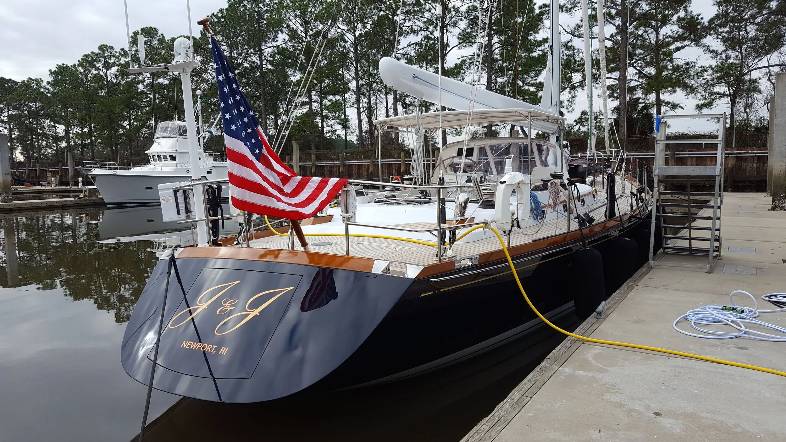 A custom built blue sailing yacht with a  newly painted hull awaits the Owner's arrival while berthed in the docking basin. 