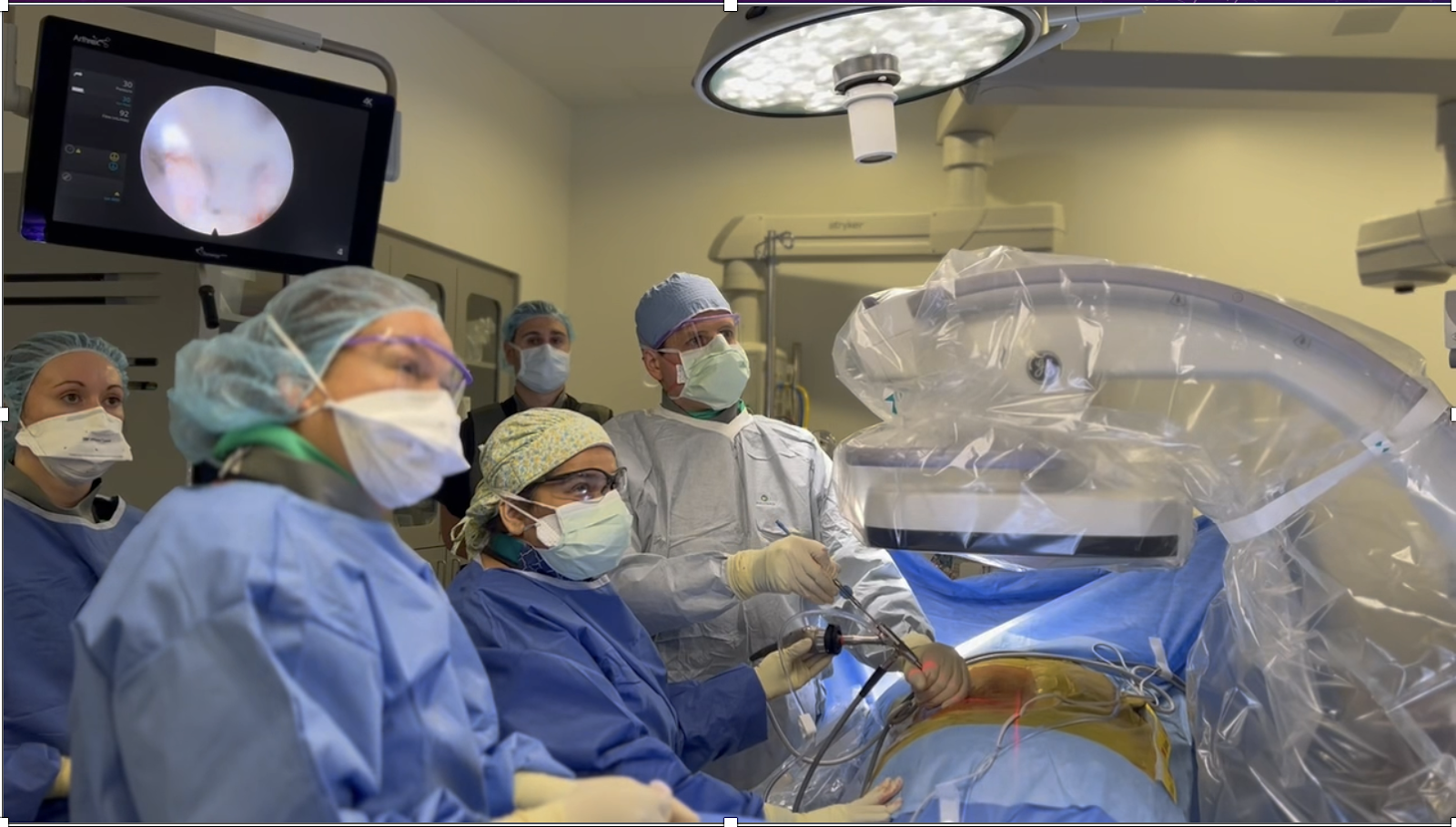 Spine care Medical team performing surgery in an operating room, with surgical instruments and robotic equipment.