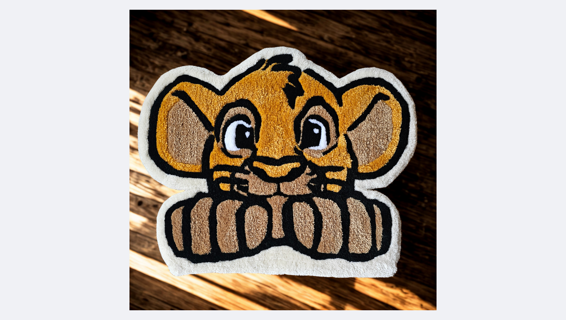 A plush rug resembling Disney's Simba from The Lion King, with detailed embroidery of the character's face, ears, and paws, placed on a wooden surface.
