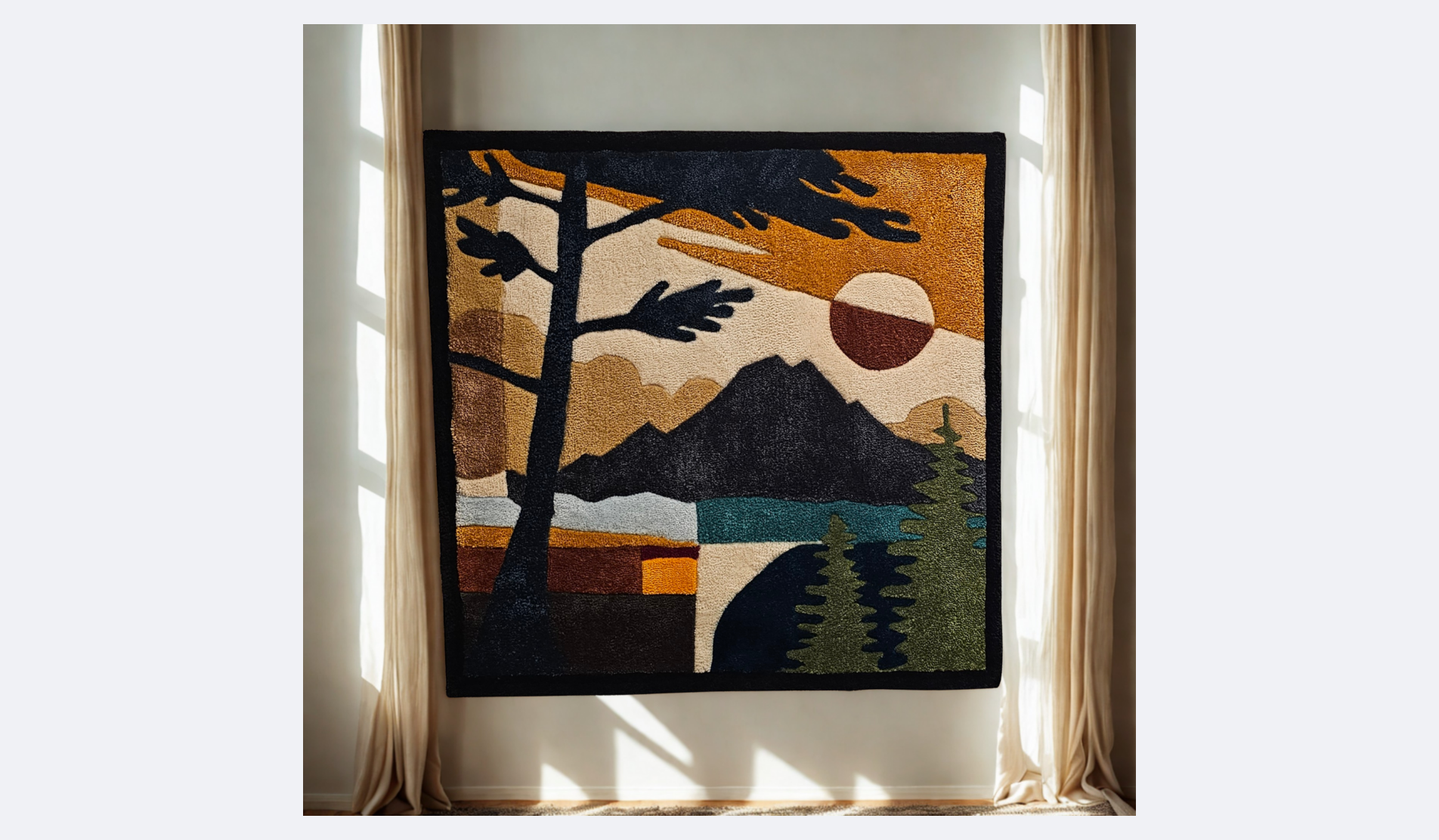 A framed tapestry depicting a mountain landscape with a large tree in the foreground, a sunset with a sun half visible over mountains, and a body of water surrounded by trees, hung on a light-colored wall between curtains.