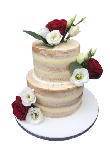 Two-tier naked wedding cake decorated with white and red roses and greenery, on a white cake board.