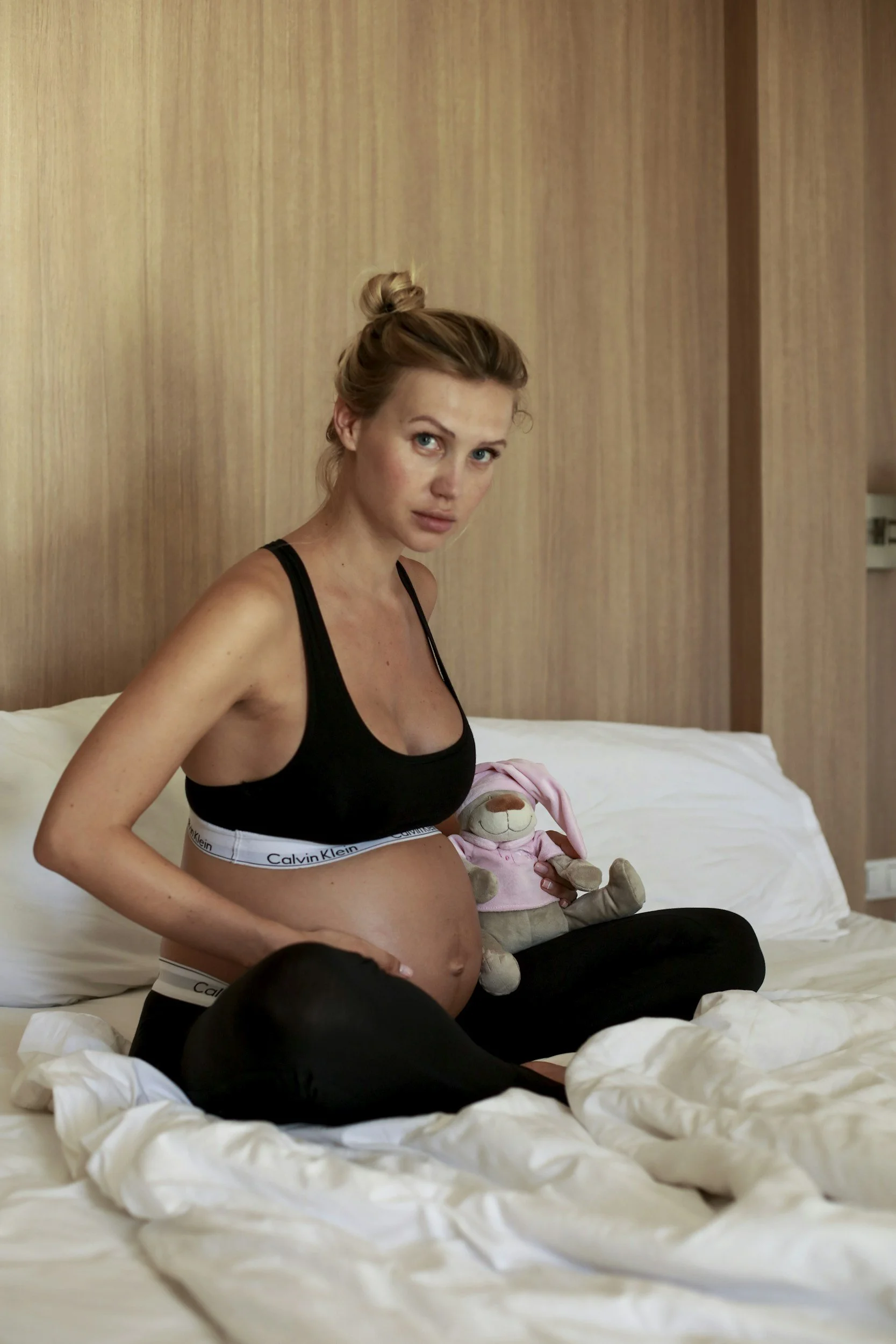 Mother sitting on bed in comfortable lounge-wear.