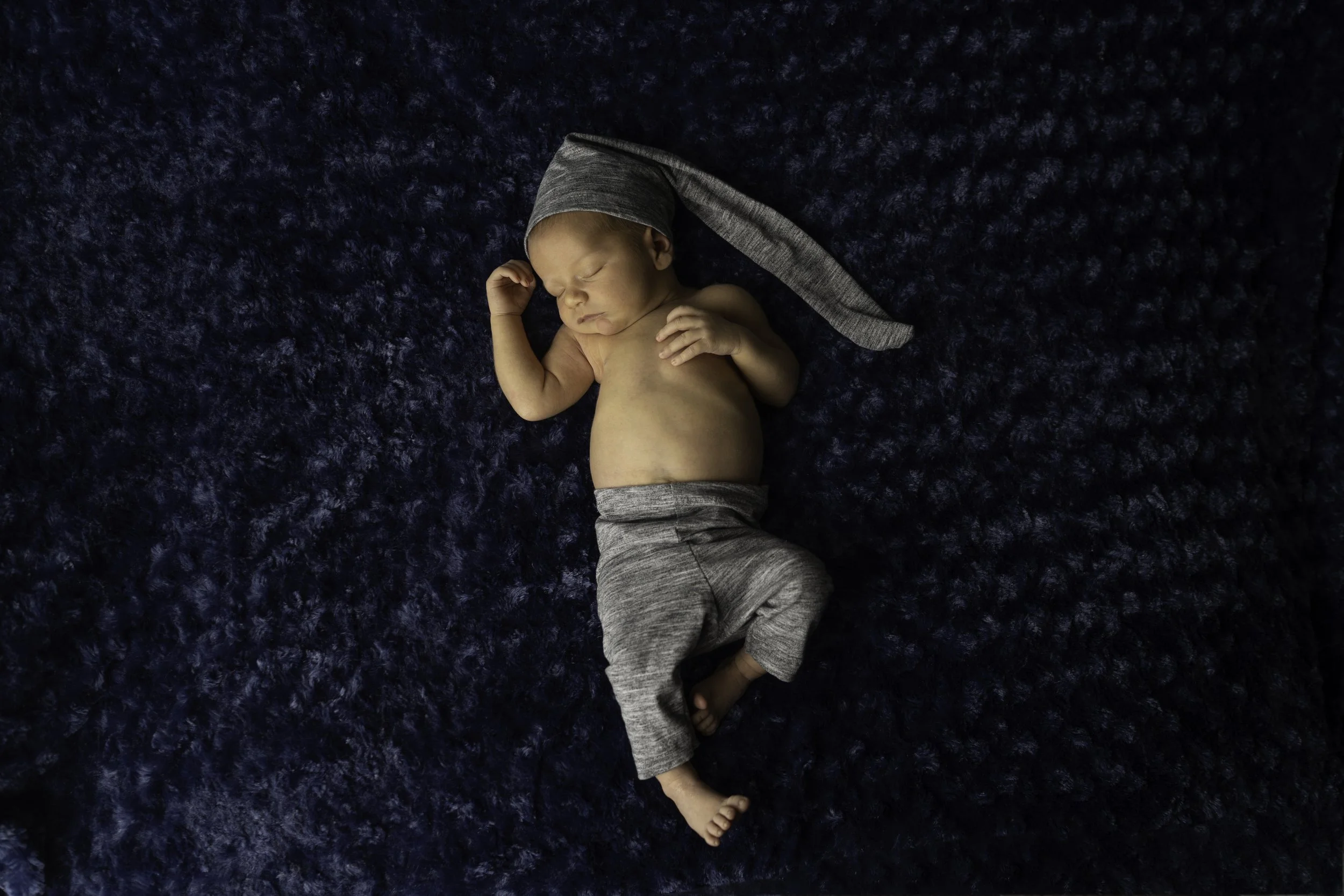 Newborn boy in grey on blue background, posed photoshoot Lacey WA.